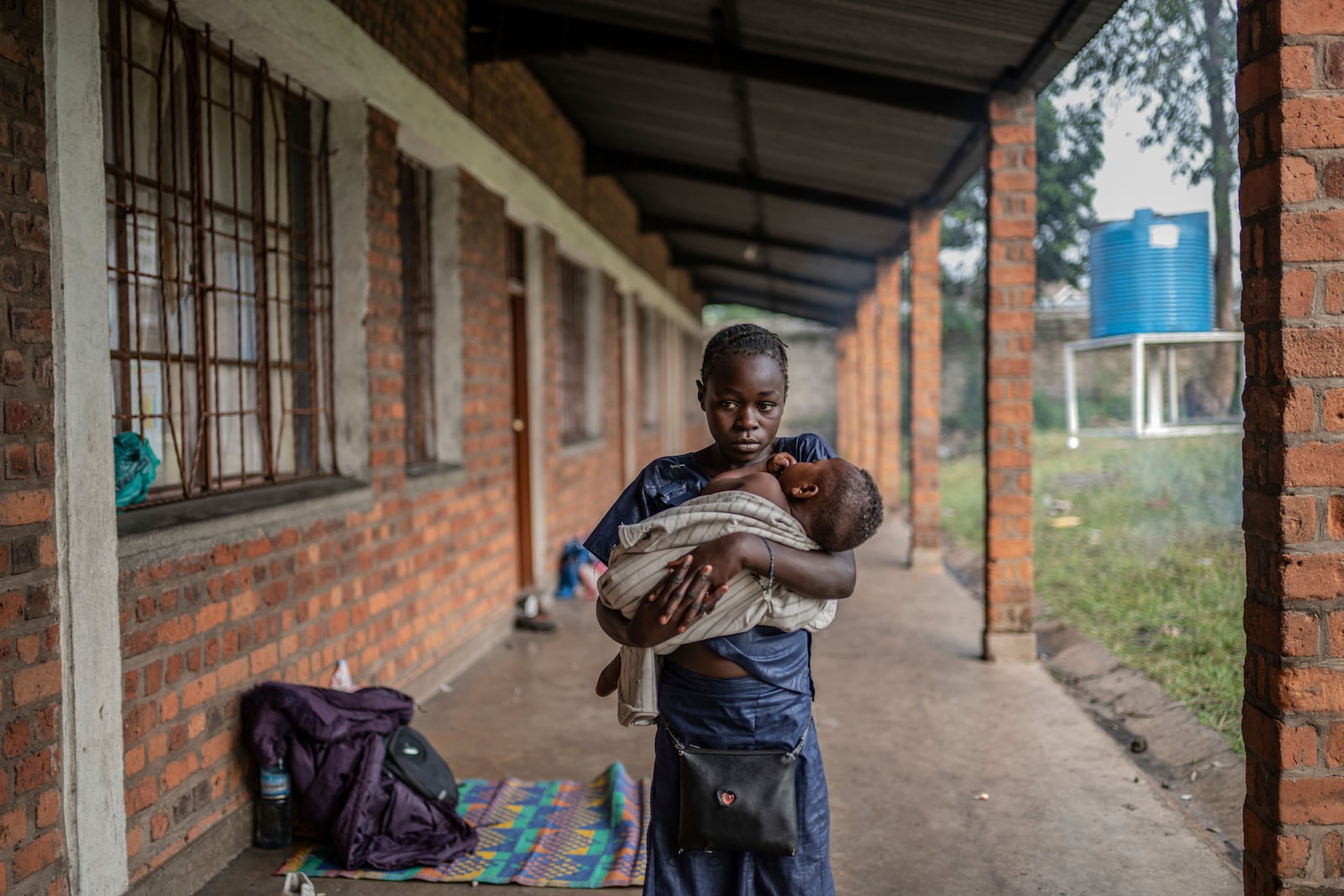 Anna,13, daughter of Zawadi Sifa, carries her young sibling in her latest displaced camp in Goma, Democratic Republic of the Congo, Thursday, Feb. 5, 2025.(AP Photo/Moses Sawasawa)