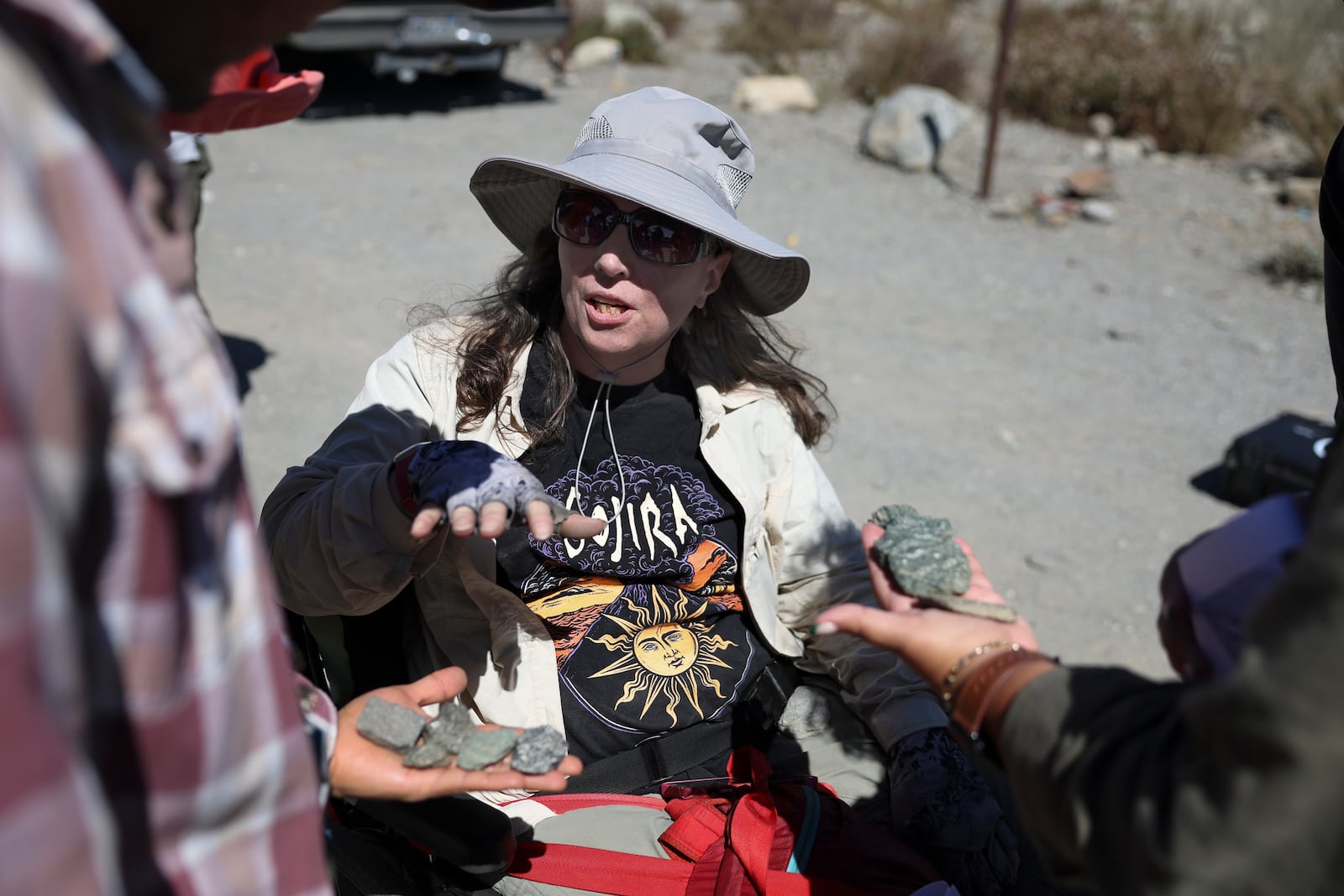 Jennifer Piatek, a planetary geologist at Central Connecticut State University, speaks with attendees on stones found during an accessible field trip to the San Andreas Fault organized by the International Association of Geoscience Diversity Thursday, Sept. 26, 2024, in San Bernadino, Calif. (AP Photo/Ryan Sun)