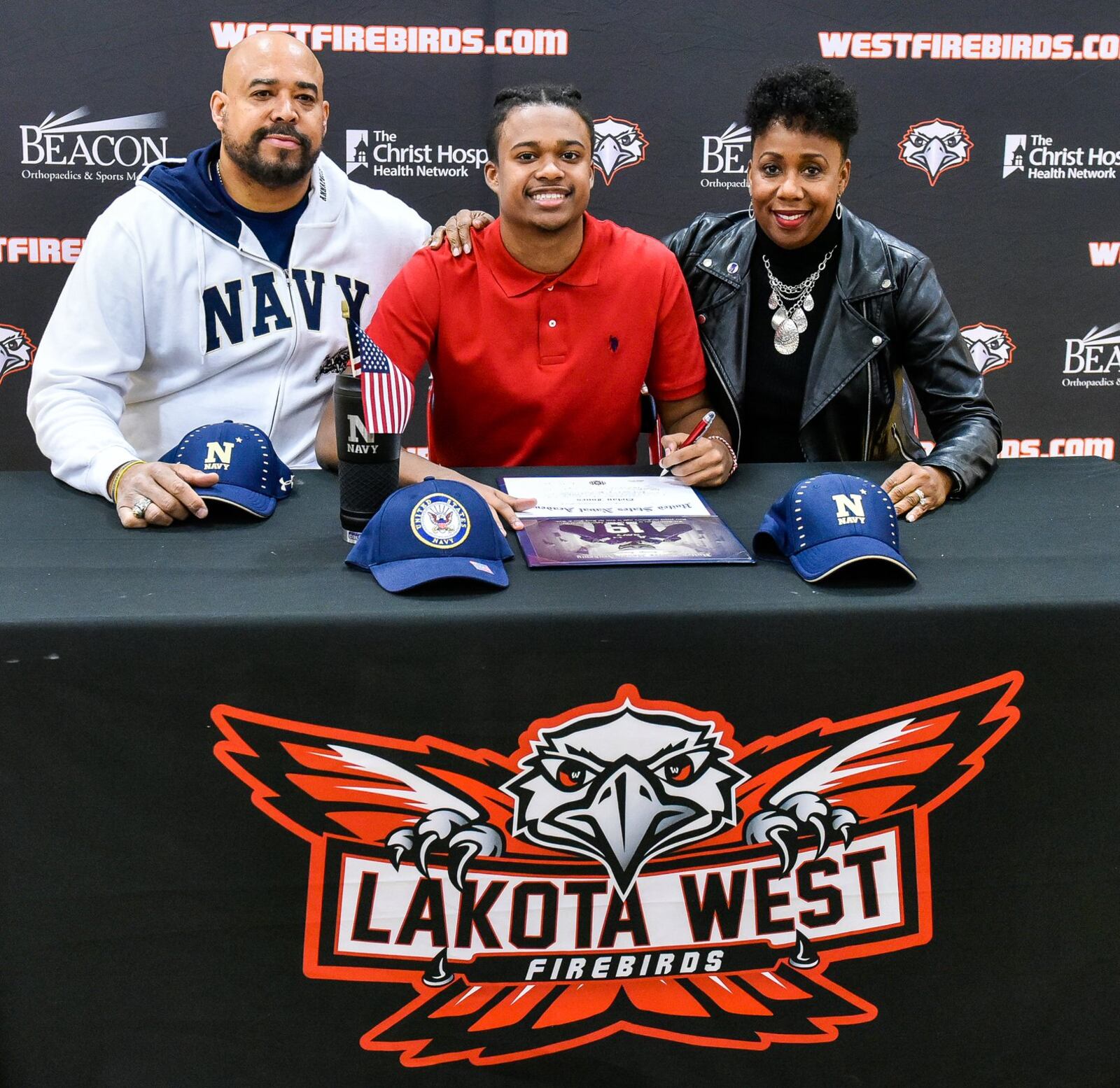 Lakota West’s Dylan Jones (middle) sits with his parents Yasmen and Dante Jones during an early National Signing Day ceremony Wednesday afternoon at West. Dylan is committed to the United States Naval Academy. NICK GRAHAM/STAFF