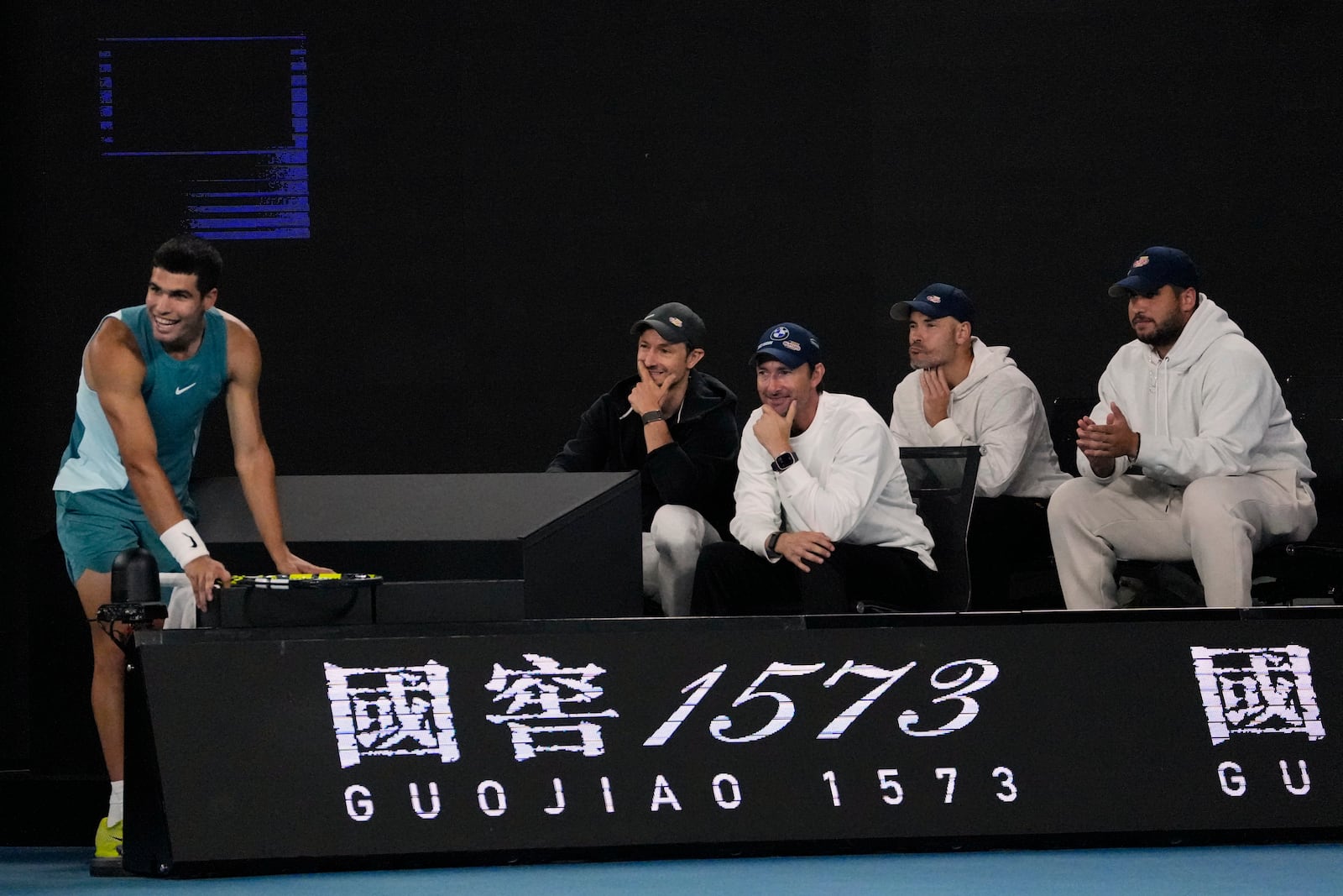 Carlos Alcaraz of Spain rests by his coaching team during his quarterfinal match against Novak Djokovic of Serbia at the Australian Open tennis championship in Melbourne, Australia, Wednesday, Jan. 22, 2025. (AP Photo/Vincent Thian)