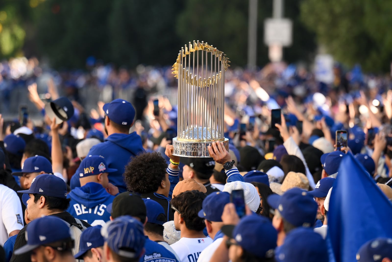 A fan holds a replica trophy during the Los Angeles Dodgers baseball World Series championship parade Friday, Nov. 1, 2024, in Los Angeles. (AP Photo/Kyusung Gong)