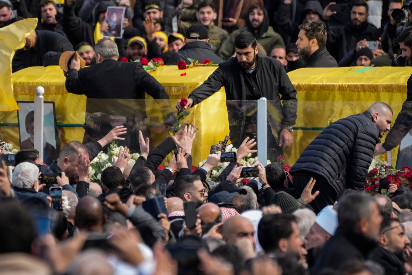 A trailer carrying the coffins containing the bodies of Hezbollah's former leader Hassan Nasrallah and his cousin and successor Hashem Safieddine drives through the crowd at the beginning of a funeral procession in the Sports City Stadium in Beirut, Lebanon, Sunday, Feb. 23, 2025. (AP Photo/Hussein Malla)