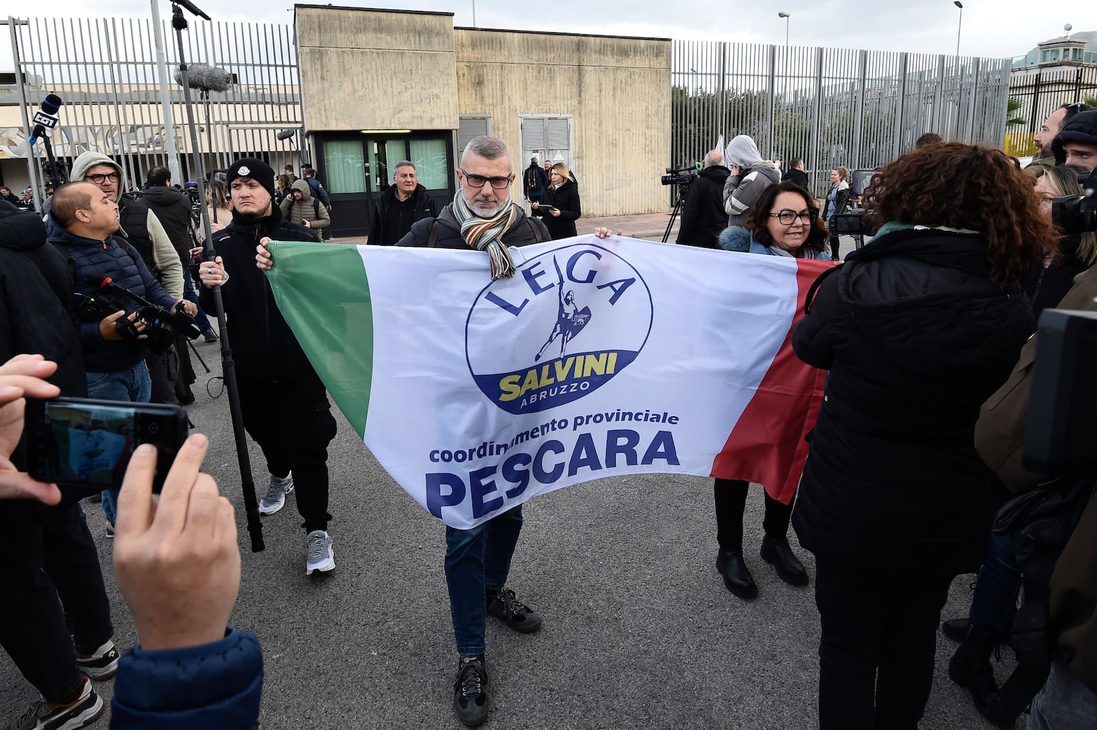 Matteo Salvini supporters show their party flag in front of the Palermo's court Friday Dec. 20, 2024 as the Italy's deputy premier awaits a verdict for preventing some 100 migrants from disembarking the rescue boat in 2019 when he was interior minister. (AP Photo/Salvatore Cavalli)