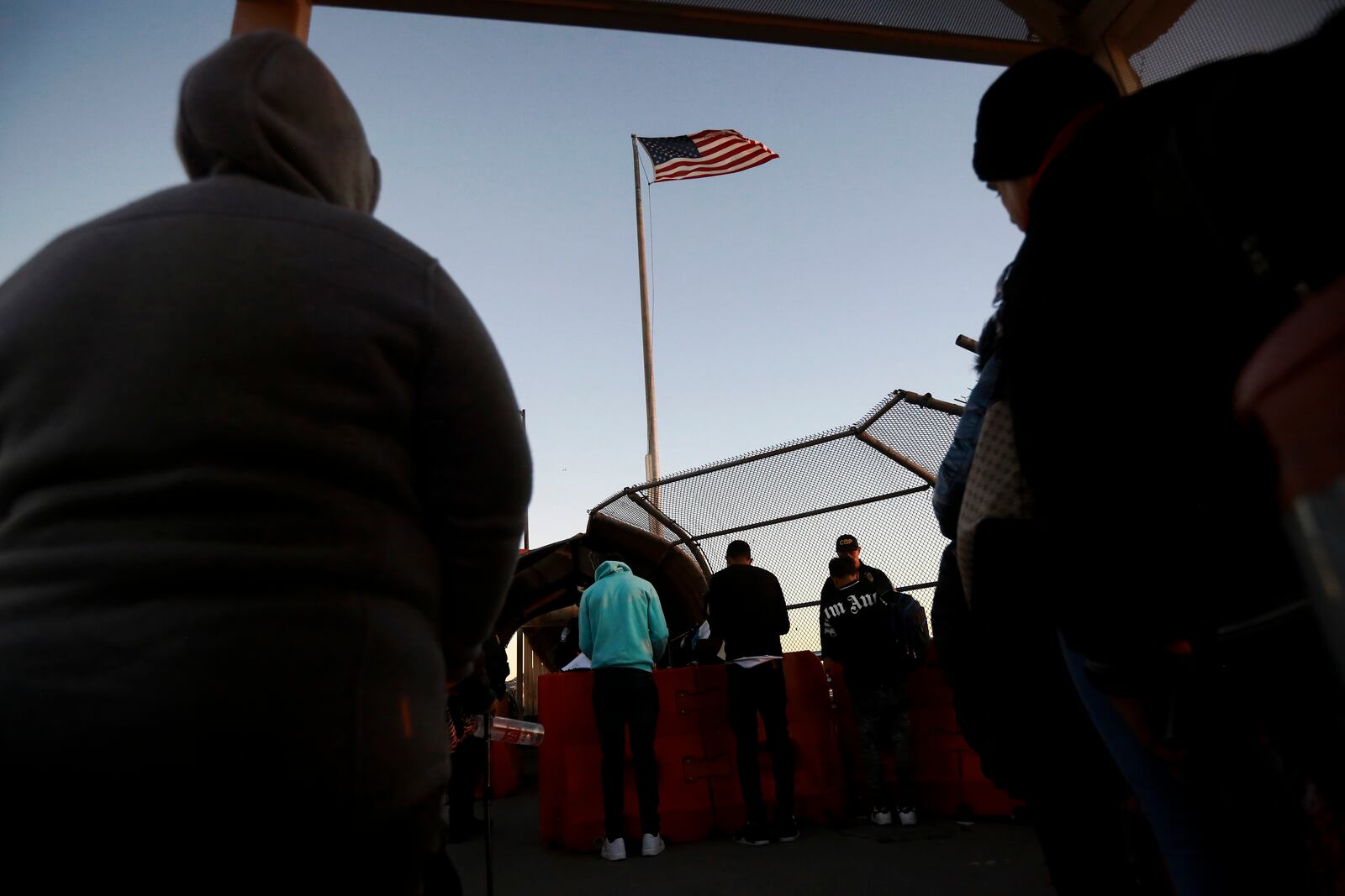 FILE - Migrants line up to present to U.S. agents, documents requesting an appointment to apply for asylum, at the Paso del Norte international bridge,in Ciudad Juarez, Mexico, Nov 5, 2024. (AP Photo/Christian Chavez, File)