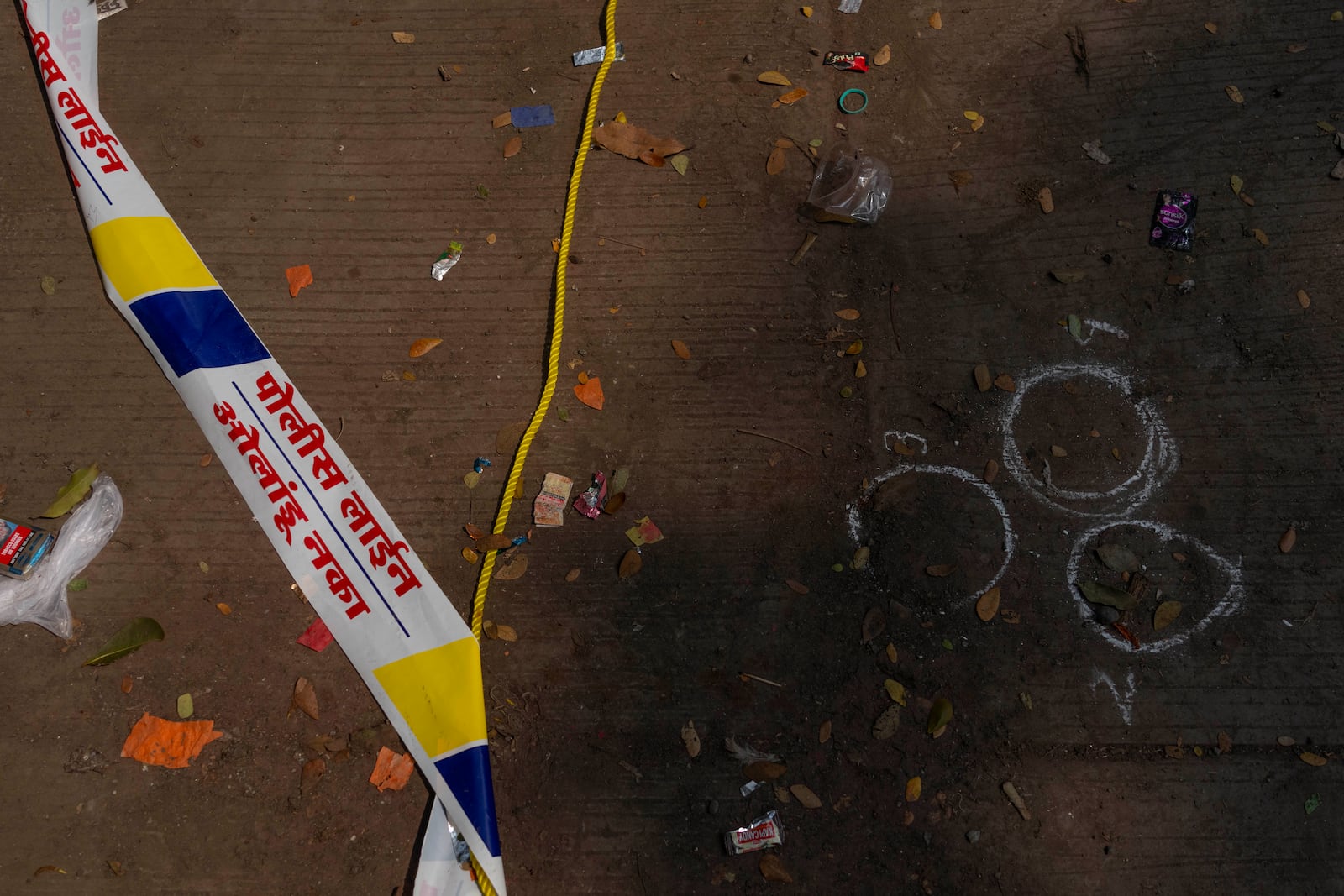 Marks made by a forensic team of the Mumbai police are visible on the spot where Baba Siddique, a senior politician, was shot at outside his son's office in Mumbai and later succumbed to his wounds in a hospital on Saturday night, in Mumbai, India, Sunday, Oct. 13, 2024. (AP Photo/Rafiq Maqbool)