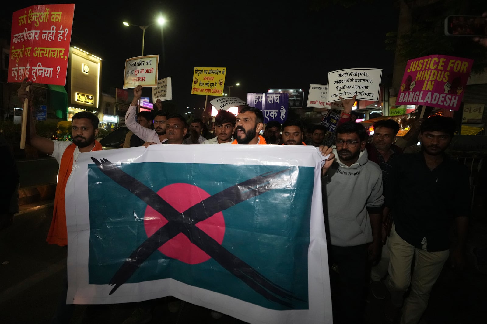 Activists of Bajarang dal, a Hindu rights group, carry a defaced symbolic flag of Bangladesh, during a protest against the alleged attacks on Hindus in Bangladesh, in Ahmedabad, India, Wednesday, Dec. 11, 2024. (AP Photo/Ajit Solanki)