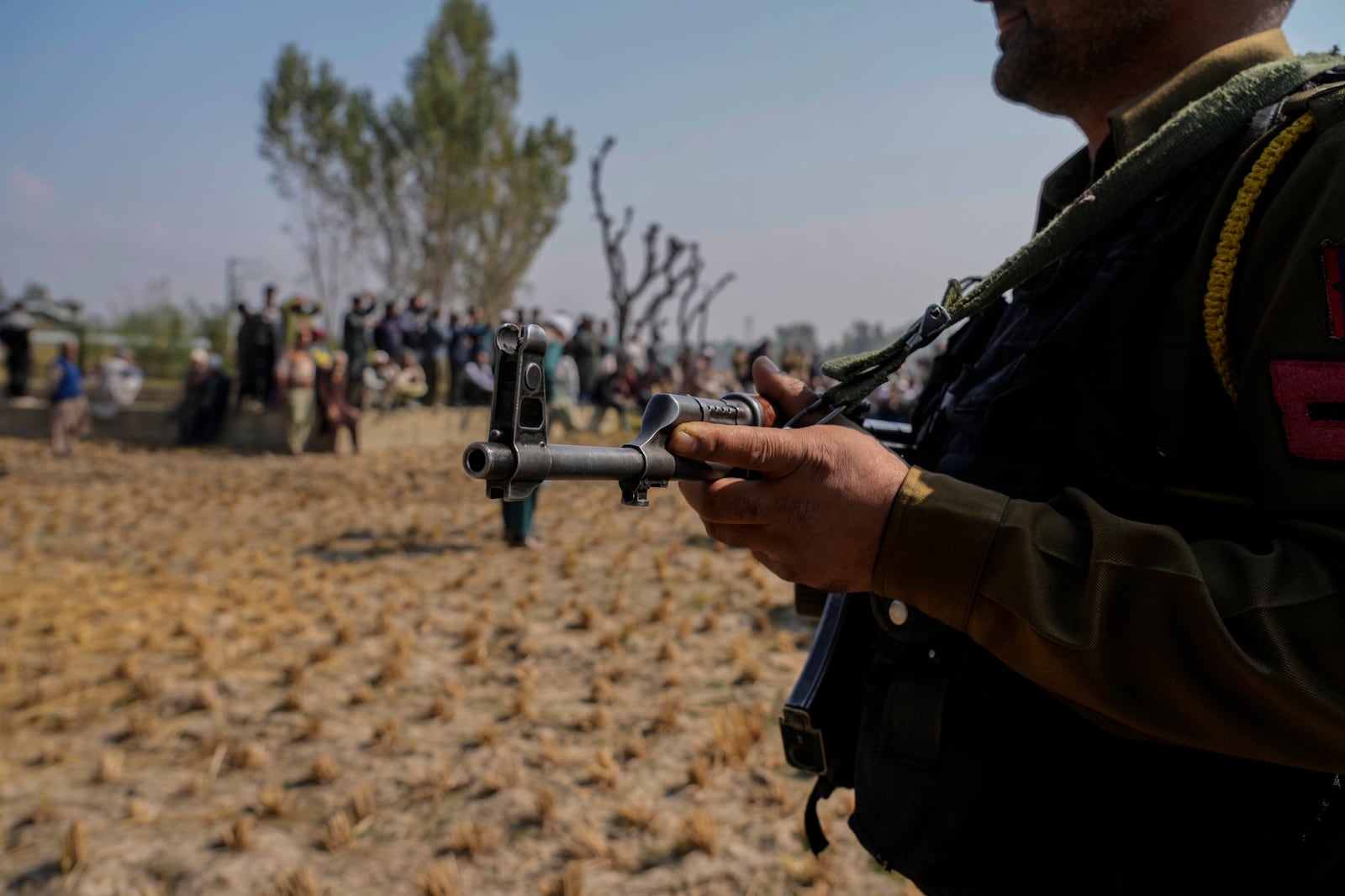 An Indian policeman guards during the funeral of Kashmiri doctor Shahnawaz who was among those killed when gunmen fired at people working on a strategic tunnel project in Indian-controlled Kashmir, at Nadigam village, southwest of Srinagar, Monday, Oct. 21, 2024. (AP Photo/Mukhtar Khan)