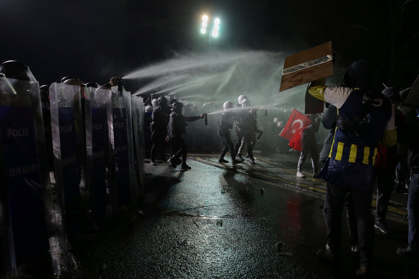 Riot police officers use pepper spray to clear protesters during a protest after Istanbul's Mayor Ekrem Imamoglu was arrested and sent to prison, in Istanbul, Turkey, Sunday, March 23, 2025. (AP Photo/Huseyin Aldemir)