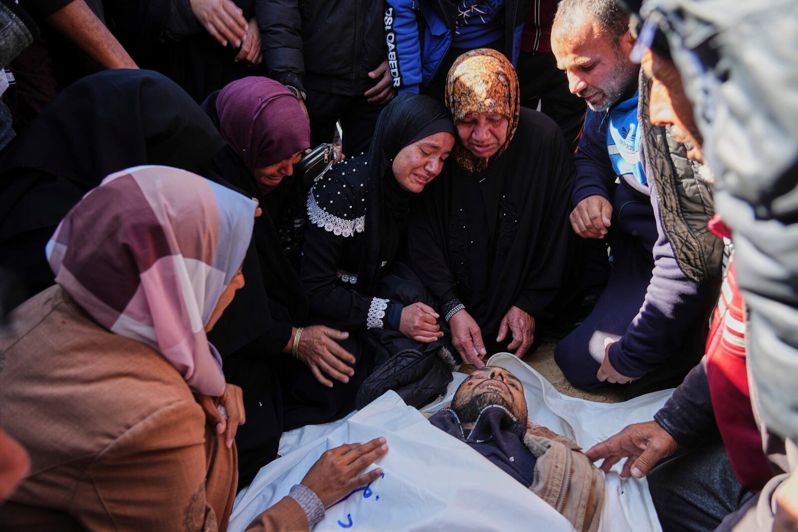 Mourners react next to the body of their relative Ahmed Al Shaer who was killed in the Israeli bombardment of the Gaza Strip as he brought for burial at Nasser Hospital in Khan Younis, Sunday, March 23, 2025. (AP Photo/Abdel Kareem Hana)