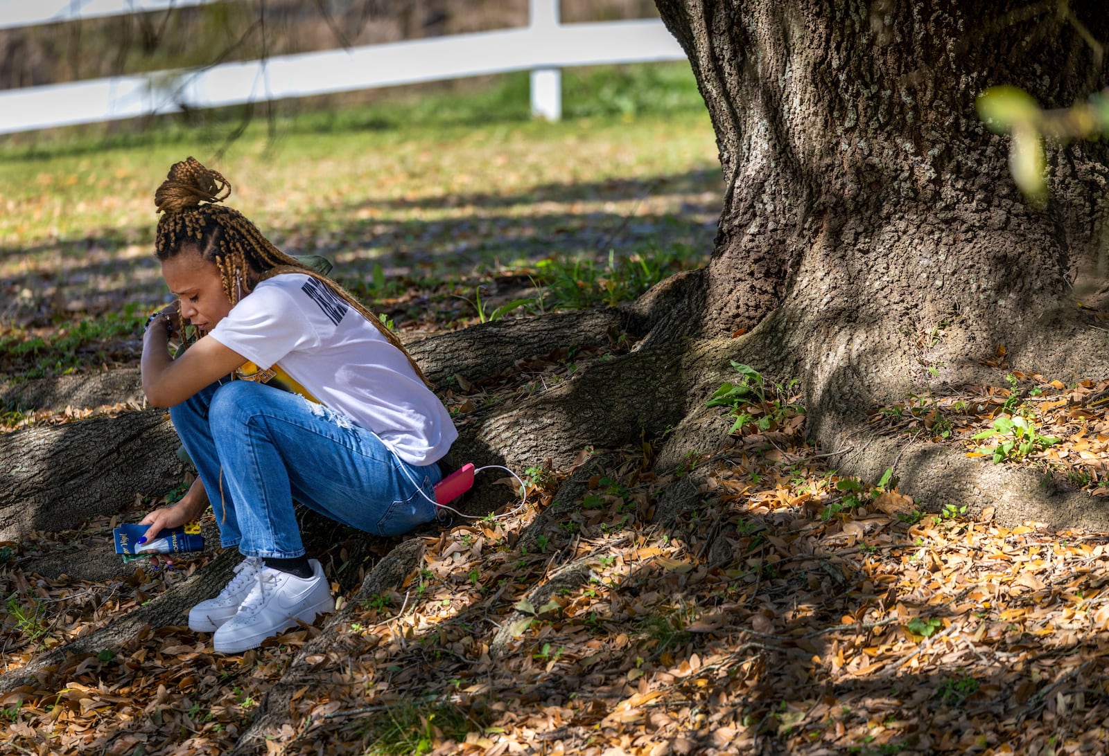 Florence Ruffin, the younger sister of Jessie Hoffman, sits underneath an oak tree looking at a photo of her brother as she and faith leaders and supporters gather outside Louisiana State Penitentiary for his planned execution in Angola, La., Tuesday, March 18, 2025. (Chris Granger/The Times-Picayune/The New Orleans Advocate via AP)