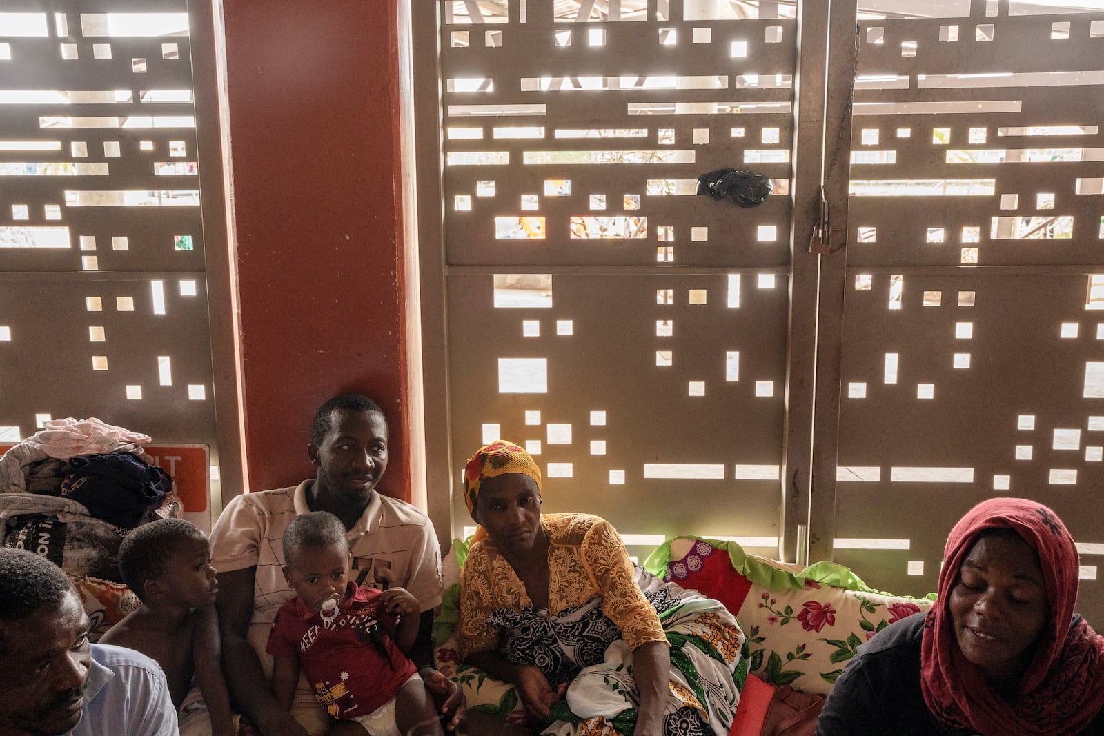 Mohamed Ankidine, 28, third left, with feet injuries, Saindou Dahabou who suffers from diabetes, and Alibouna Haithouna, 33, find refuge at the Lycée des Lumières after losing their homes, in Mamoudzou, Mayotte, Thursday, Dec. 19, 2024. (AP Photo/Adrienne Surprenant)