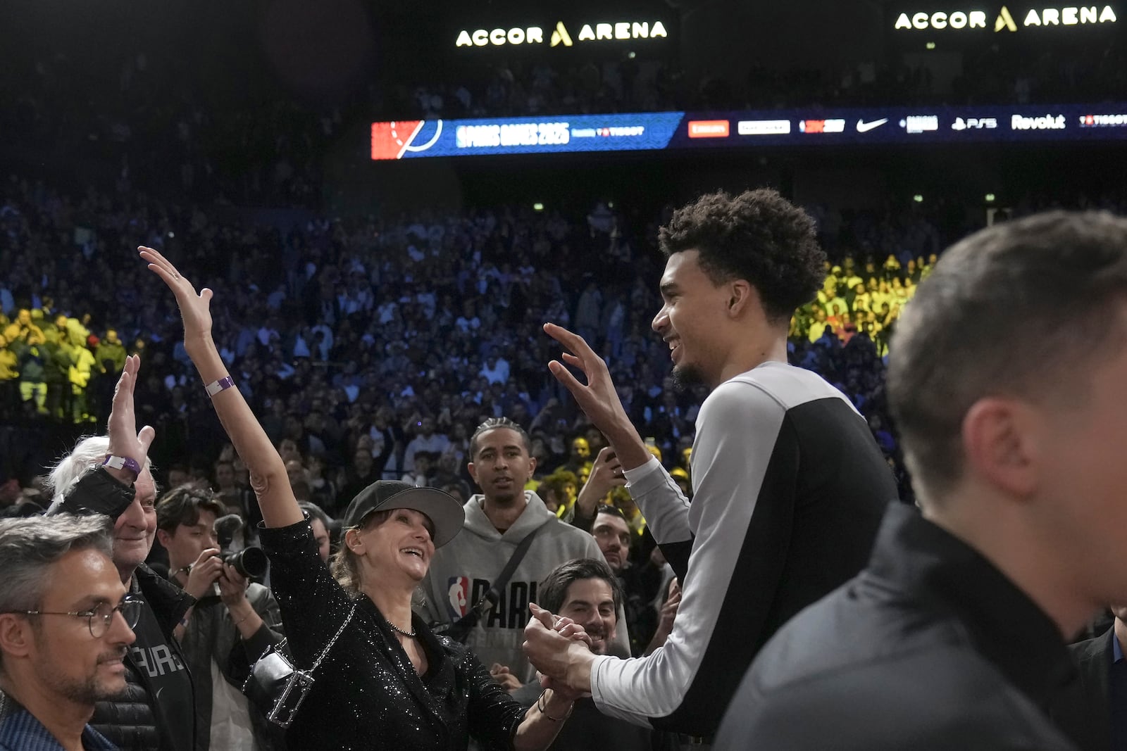 San Antonio Spurs center Victor Wembanyama, middle right, celebrates with fans after a Paris Games 2025 NBA basketball game between the Indiana Pacers and the Spurs in Paris, Thursday, Jan. 23, 2025. (AP Photo/Thibault Camus)