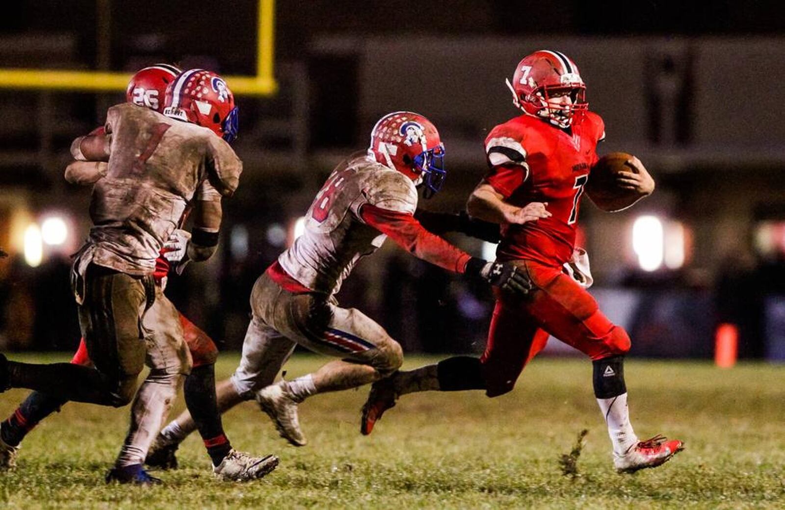 Madison quarterback Mason Whiteman (7) tries to get away from several Portsmouth defenders during last Saturday night’s 26-0 win in a Division V, Region 20 playoff game at Brandenburg Field in Madison Township. NICK GRAHAM/STAFF