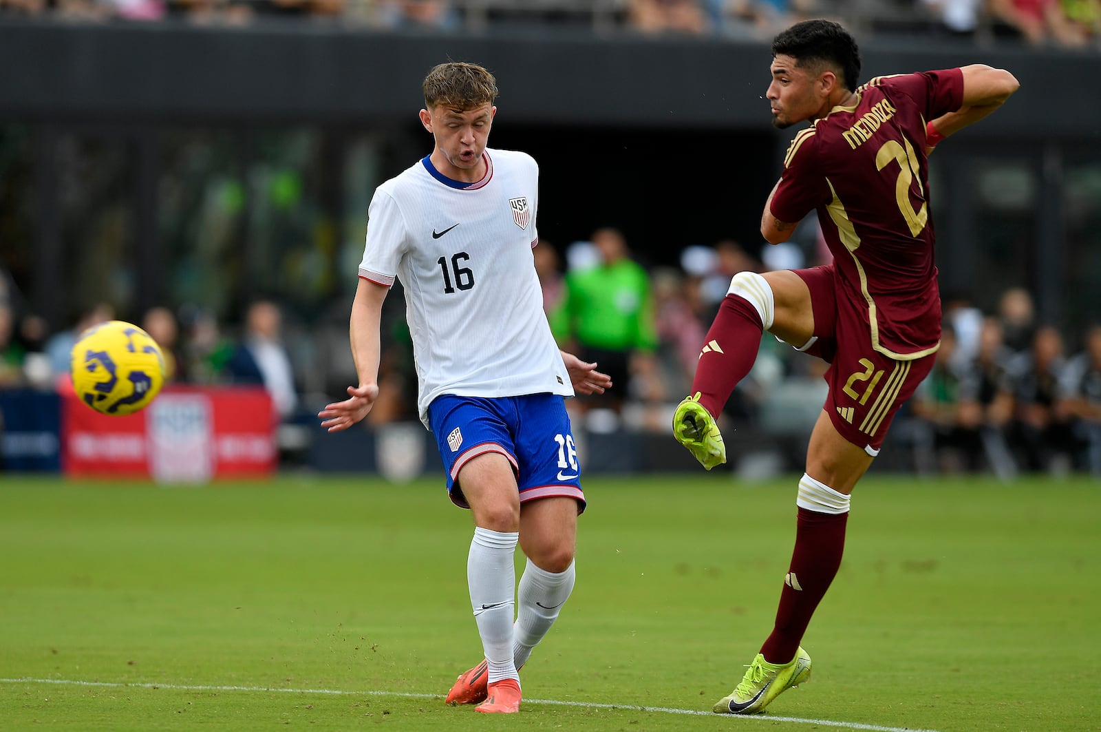 Venezuela midfielder Gleiker Mendoza (21) kicks the ball past United States midfielder Jack McGlynn (16) during the first half of an international friendly soccer game, Saturday, Jan 18, 2025, in Fort Lauderdale, Fla. (AP Photo/Michael Laughlin)