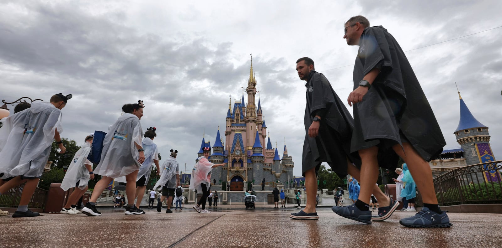 Guests weather early bands of rain from Hurricane Milton at the Magic Kingdom at Walt Disney World in Bay Lake, Fla., Wednesday, Oct. 9, 2024. (Joe Burbank/Orlando Sentinel via AP)