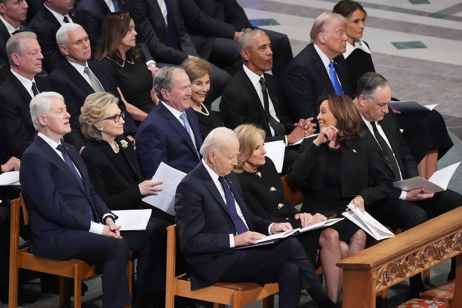 Vice President Kamala Harris talks with former President George W. Bush as from the front row, from left, President Joe Biden, first lady Jill Biden, second gentleman Doug Emhoff and second row from left, former President Bill Clinton, former Secretary of State Hillary Clinton, Laura Bush, former President Barack Obama, President-elect Donald Trump and Melania Trump, during the state funeral for former President Jimmy Carter at Washington National Cathedral in Washington, Thursday, Jan. 9, 2025. (AP Photo/Jacquelyn Martin)