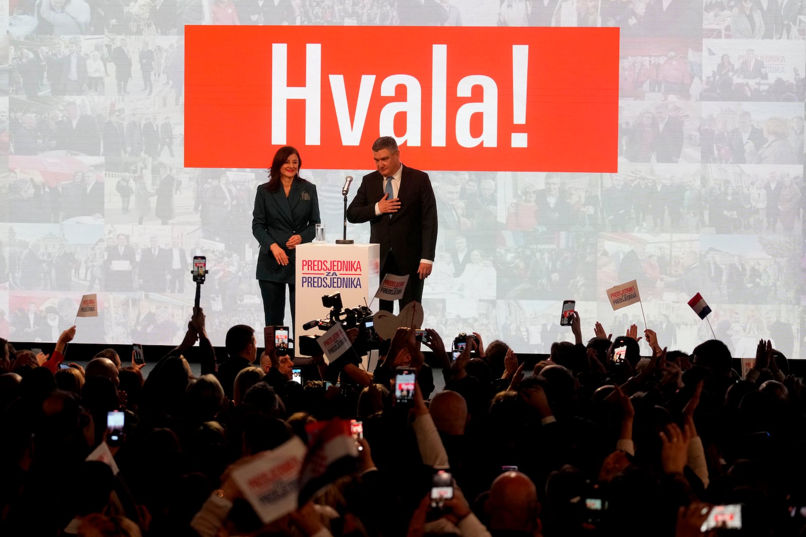 President incumbent Zoran Milanovic with his wife Sanja Music Milanovic greets his supporters as the preliminary results grant him victory in a runoff vote for the Croatian presidential election in Zagreb, Croatia, Sunday, Jan. 12, 2025. The sign reads "Thank You". (AP Photo/Darko Bandic)