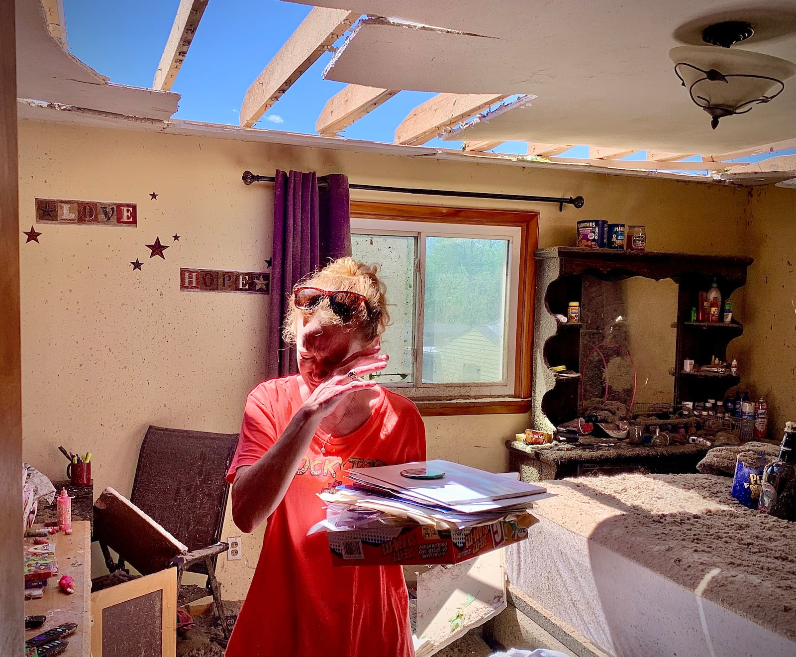 Greenville resident Brenda Pollitt wipes tears from her eyes as she removes important papers from her bedroom Wednesday, May 8, 2024. Pollitt and her children ran downstairs when the strong storm hit Tuesday evening, tearing off much of her roof. She and her family were uninjured. MARSHALL GORBY\STAFF