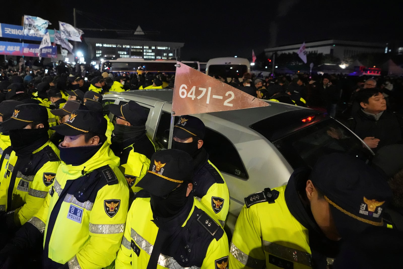 Military vehicles are surrounded by police officers outside the National Assembly in Seoul, South Korea, Wednesday, Dec. 4, 2024. (AP Photo/Lee Jin-man)