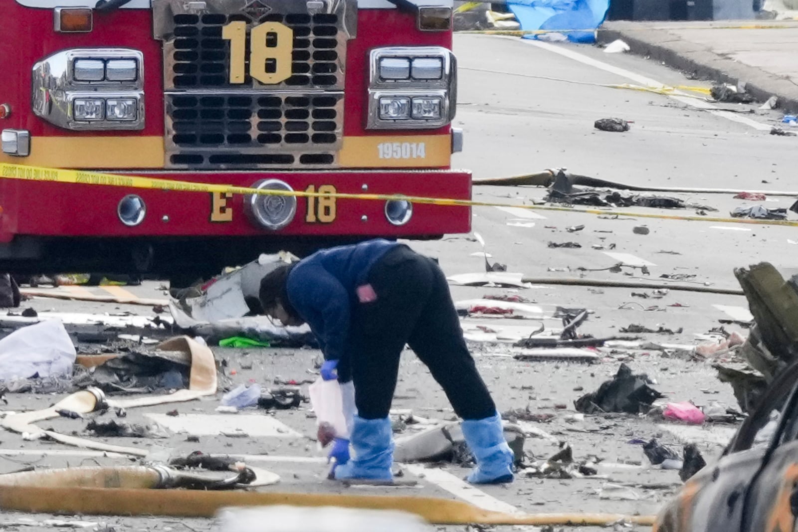 An investigator works the scene after a small plane crashed in Philadelphia, Saturday, Feb. 1, 2025. (AP Photo/Matt Rourke)