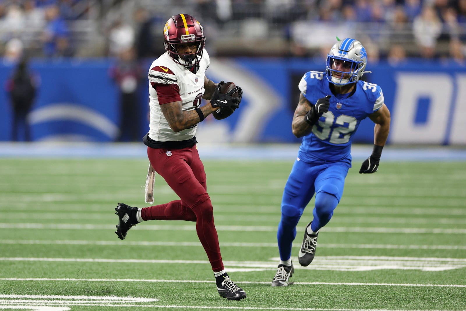 Washington Commanders wide receiver Dyami Brown (2) catches as pass as Detroit Lions safety Brian Branch (32) defends during the first half of an NFL football divisional playoff game, Saturday, Jan. 18, 2025, in Detroit. (AP Photo/Mike Mulholland)