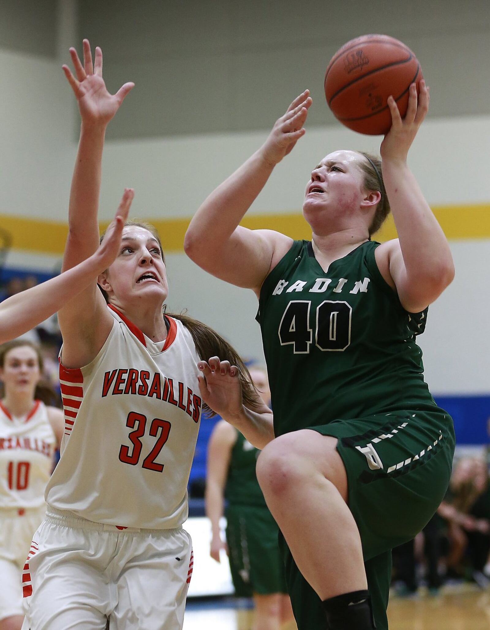 Badin’s Emma Broermann goes up and over Versailles’ Danielle Winner on Wednesday night during a Division III regional semifinal at Springfield. BILL LACKEY/STAFF