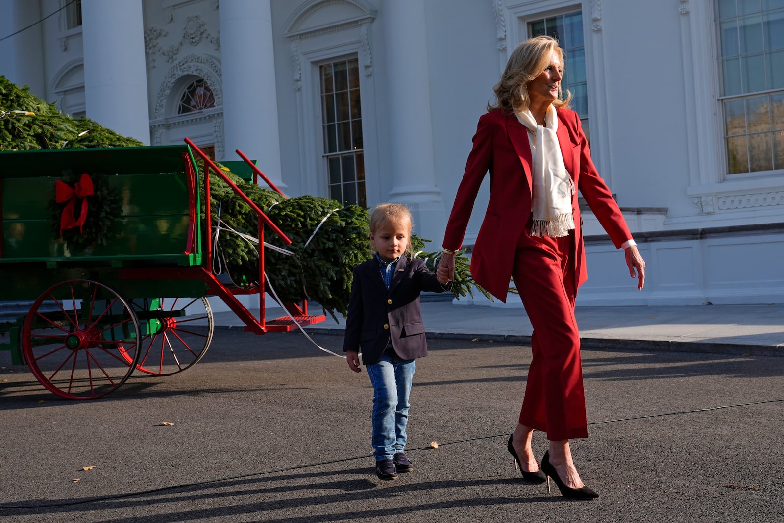 First lady Jill Biden, right, walks with her grandson Beau Biden after receiving the official 2024 White House Christmas Tree on the North Portico of the White House in Washington, Monday, Nov. 25, 2024. Cartner's Christmas Tree Farm from Newland, N.C., provided the Fraser fir that will be displayed in the Blue Room of the White House. (AP Photo/Susan Walsh)