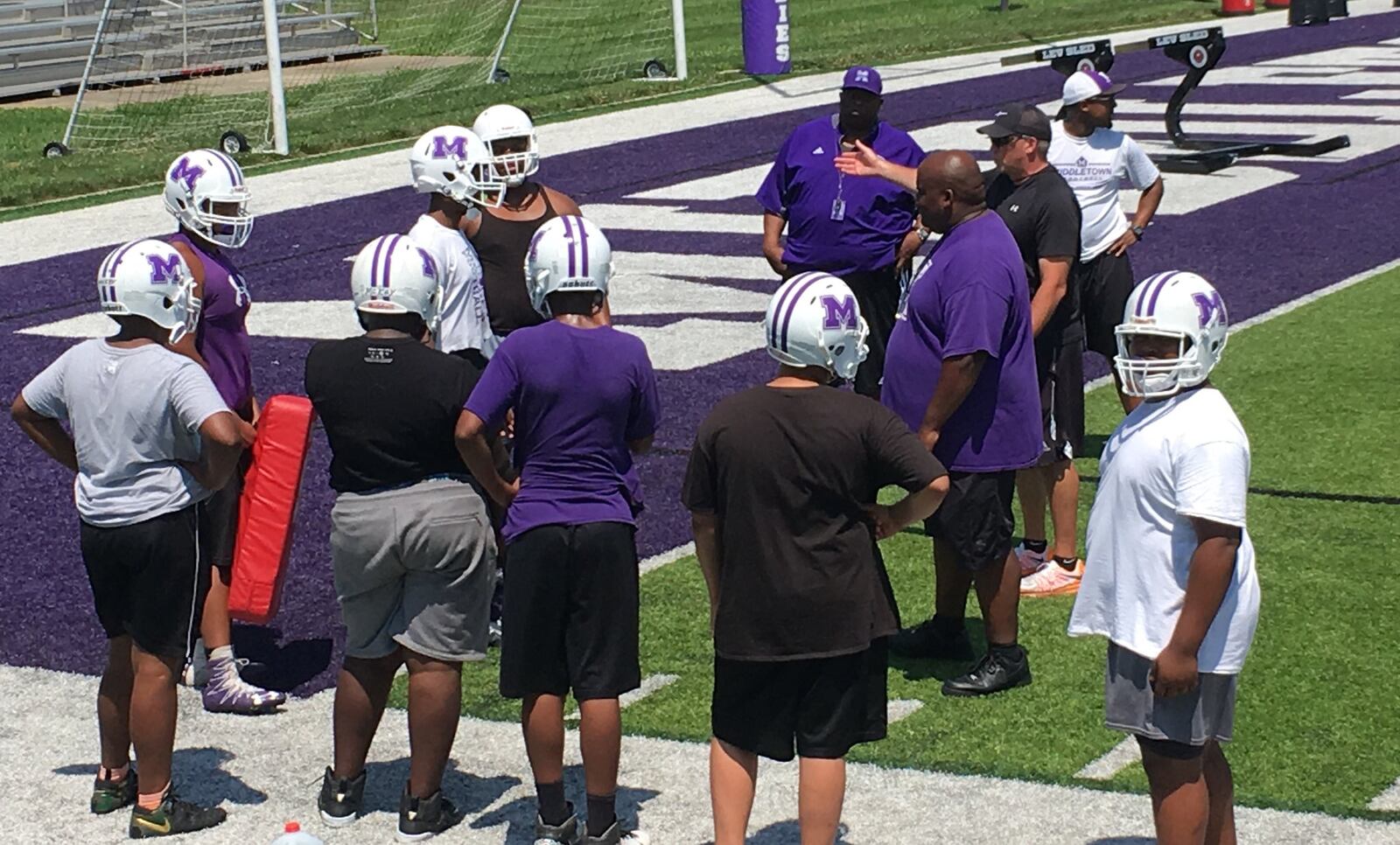 New Middletown High School defensive coordinator John Cupps (black shirt) makes a point during the first day of practice at Barnitz Stadium in Middletown on Monday. RICK CASSANO/STAFF