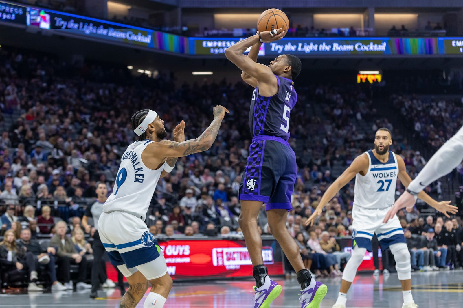 Sacramento Kings guard De'Aaron Fox (5) makes a jump shot over Minnesota Timberwolves guard Nickeil Alexander-Walker (9) during the first half of an Emirates NBA Cup basketball game Friday, Nov. 15, 2024, in Sacramento, Calif. (AP Photo/Sara Nevis)