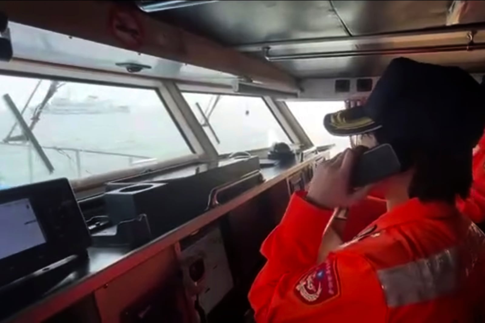 In this image taken off a video released by the Taiwan Coast Guard, a member of Taiwan Coast Guard reacts to a Chinese Coast Guard vessel entering the waters near Kinman Island on Tuesday, Feb. 25, 2025. (Taiwan Coast Guard via AP)