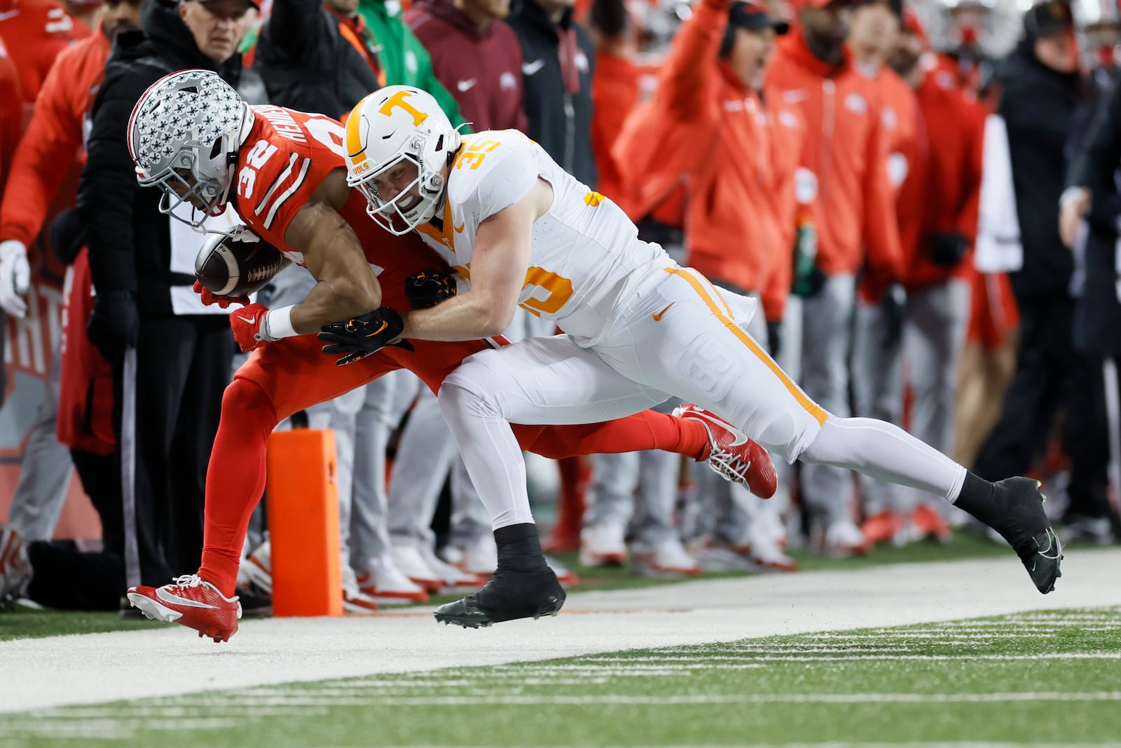 Ohio State running back TreVeyon Henderson, left, is forced out of bounds by Tennessee defensive back Will Brooks, right, during the first half in the first round of the College Football Playoff, Saturday, Dec. 21, 2024, in Columbus, Ohio. (AP Photo/Jay LaPrete)