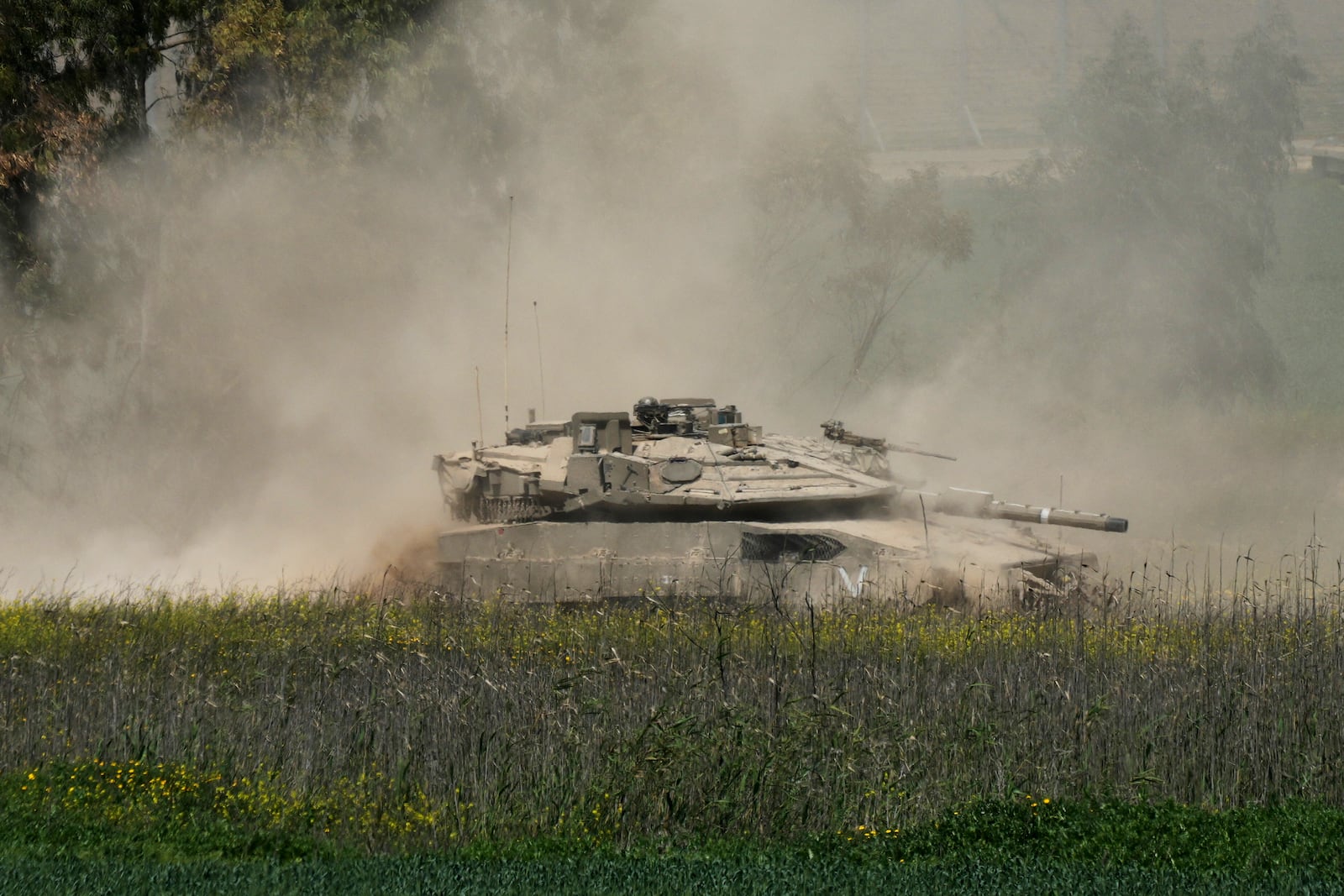 An Israeli tank maneuvers on the border with northern Gaza Strip as seen from southern Israel, Tuesday, March 18, 2025. (AP Photo/Ohad Zwigenberg)