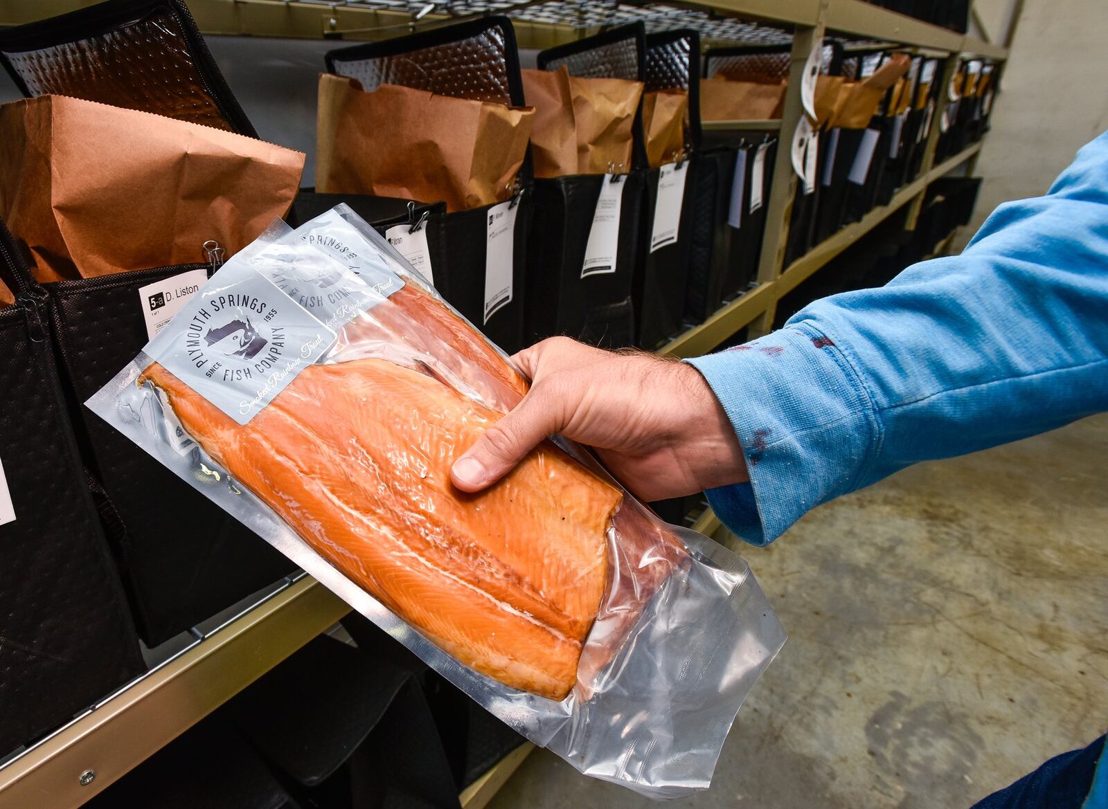 Grant Johnson, with Plymouth Springs Fish Company from Wisconsin, delivers smoked rainbow trout to Market Wagon Thursday, Oct. 11, at their West Chester Twp. distribution location. 