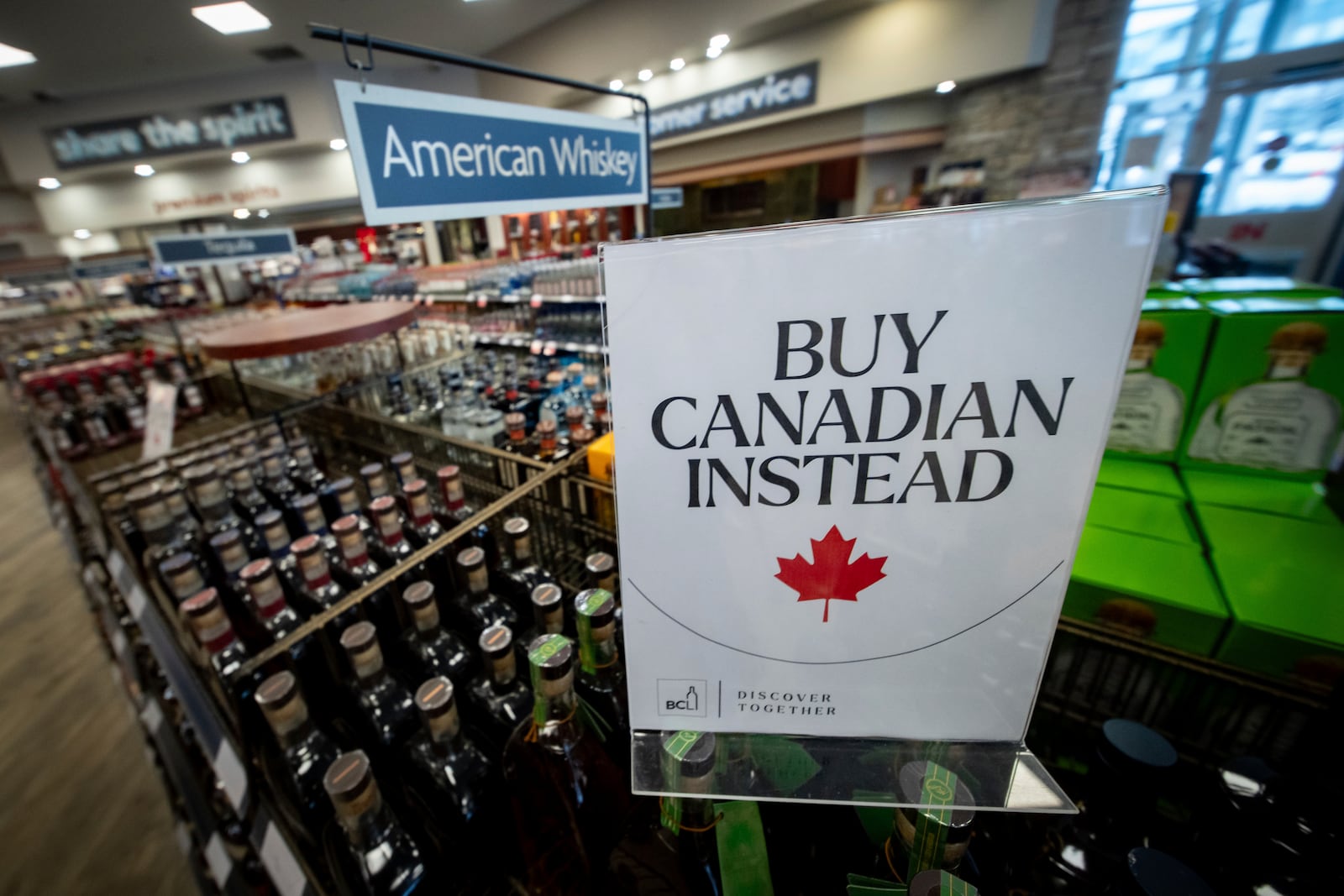 FILE - A sign is placed in front of the American whiskey section at a B.C. liquor store after top selling American made products have been removed from shelves in Vancouver, B.C., Feb. 2, 2025. (Ethan Cairns/The Canadian Press via AP, file)