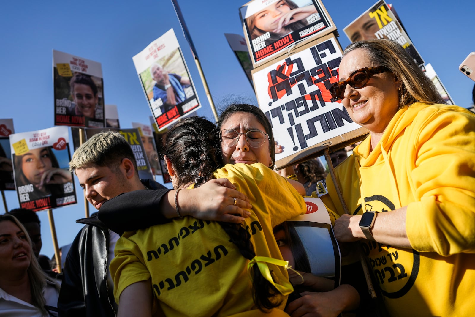 People react as they watch broadcast of the release of Israeli soldier Agam Berger, one of eight hostages set to be released today as part of a ceasefire in the Gaza Strip, in Tel Aviv, Israel, Thursday, Jan. 30, 2025. (AP Photo/Oded Balilty)