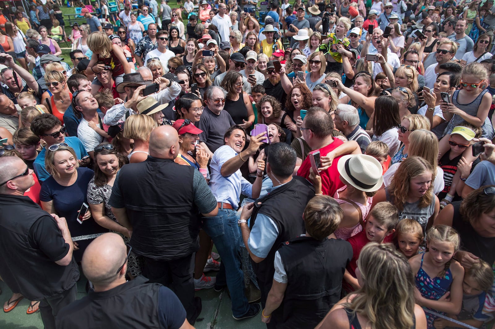 FILE - Prime Minister Justin Trudeau, centre left, takes a selfie with a person in a wheelchair during a visit to B.C. Day celebrations in Penticton, B.C., on Aug. 6, 2018. (Darryl Dyck/The Canadian Press via AP, File)