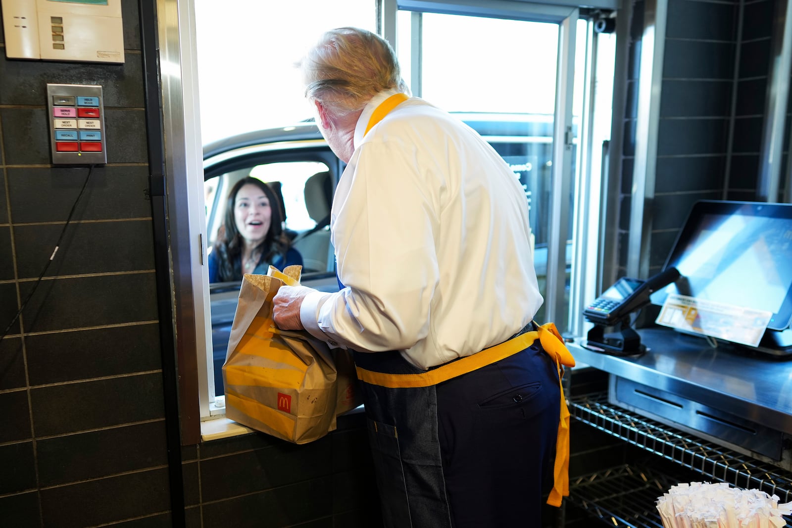 Republican presidential nominee former President Donald Trump hands an order to an employee at the drive-thru window during a visit to McDonald's in Feasterville-Trevose, Pa., Sunday, Oct. 20, 2024. (Doug Mills/The New York Times via AP, Pool)