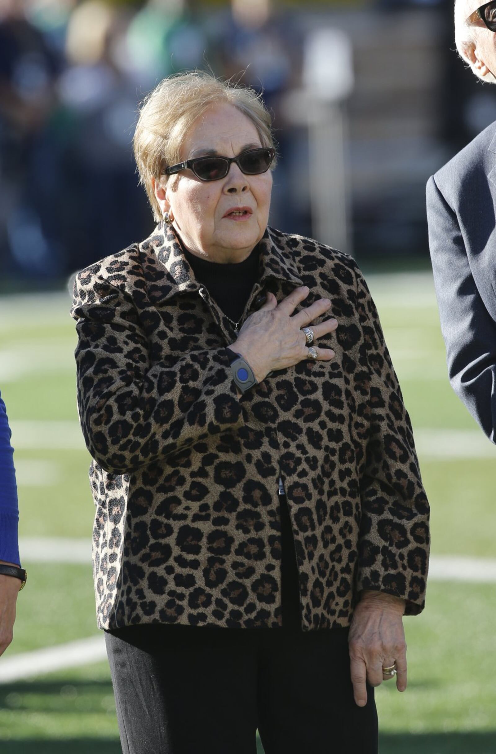 Katie Parseghian, widow of legendary coach Ara Parseghian, watches the raising of the American flag before Saturday night’s Notre Dame-Miami game at Notre Dame Stadium in Notre Dame, Ind. CHARLES REX ARBOGAST/ASSOCIATED PRESS