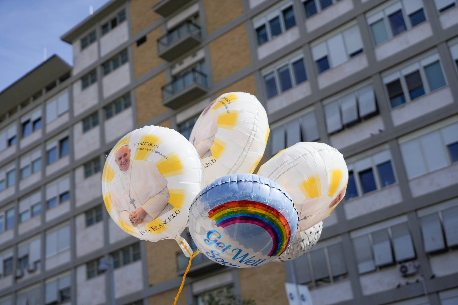 Balloons with pictures of Pope Francis are seen outside the Agostino Gemelli Polyclinic in Rome, Sunday, Feb. 23, 2025, where the Pontiff is hospitalized since Feb. 14. (AP Photo/Gregorio Borgia)