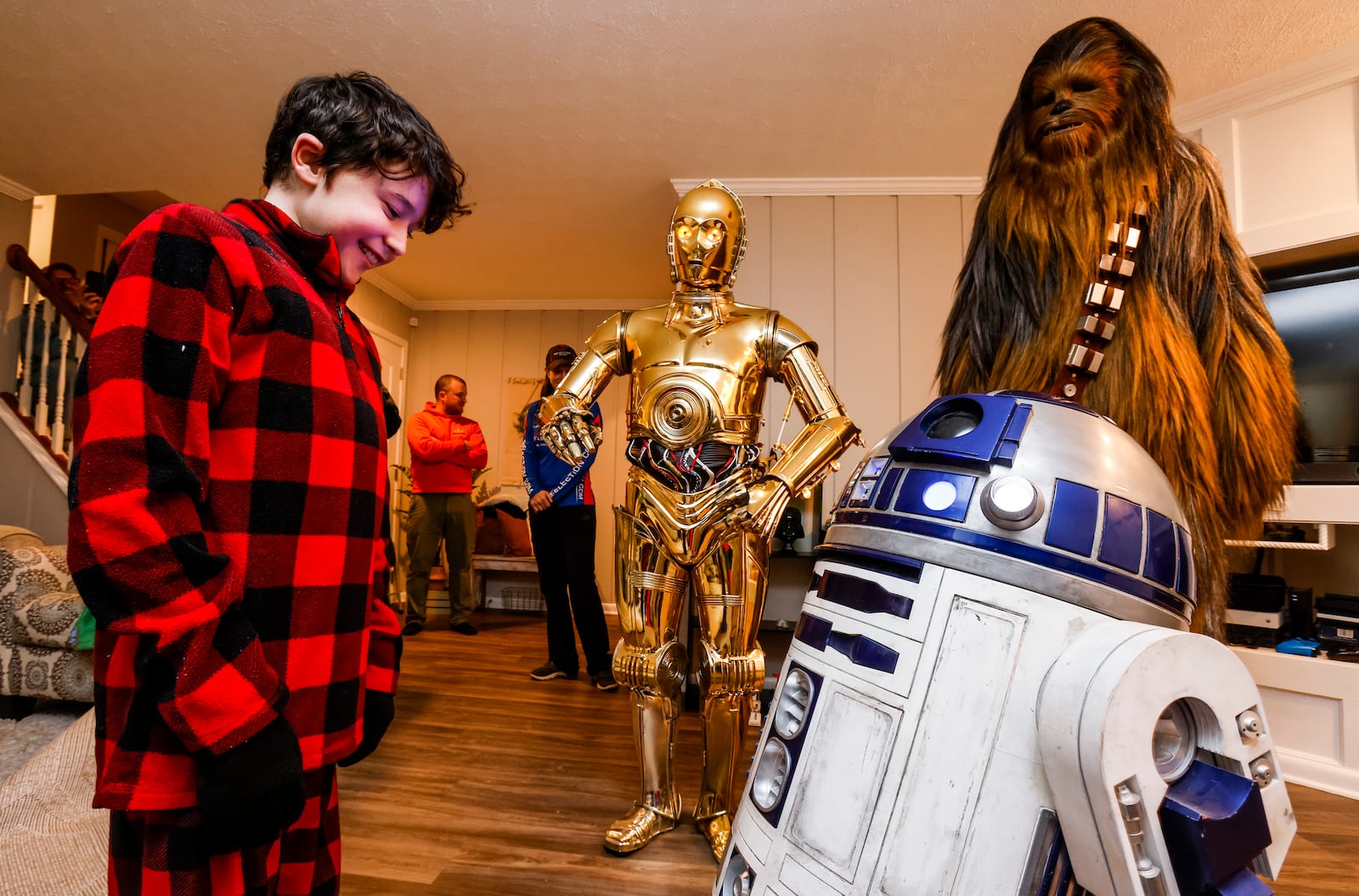 Porter Sowards, a 10-year-old who is battling brain cancer, was surprised with a visit from Star Wars characters, C3PO, portrayed by Tim O'Sullivan, R2D2 and Chewbacca, portrayed by Joey Arielle, at his home Friday, Nov. 12, 2021 in Middletown. Team Fastax also presented Porter and his family with a Dreams of Fastrax certificate for a plane ride and indoor wind tunnel session. NICK GRAHAM / STAFF