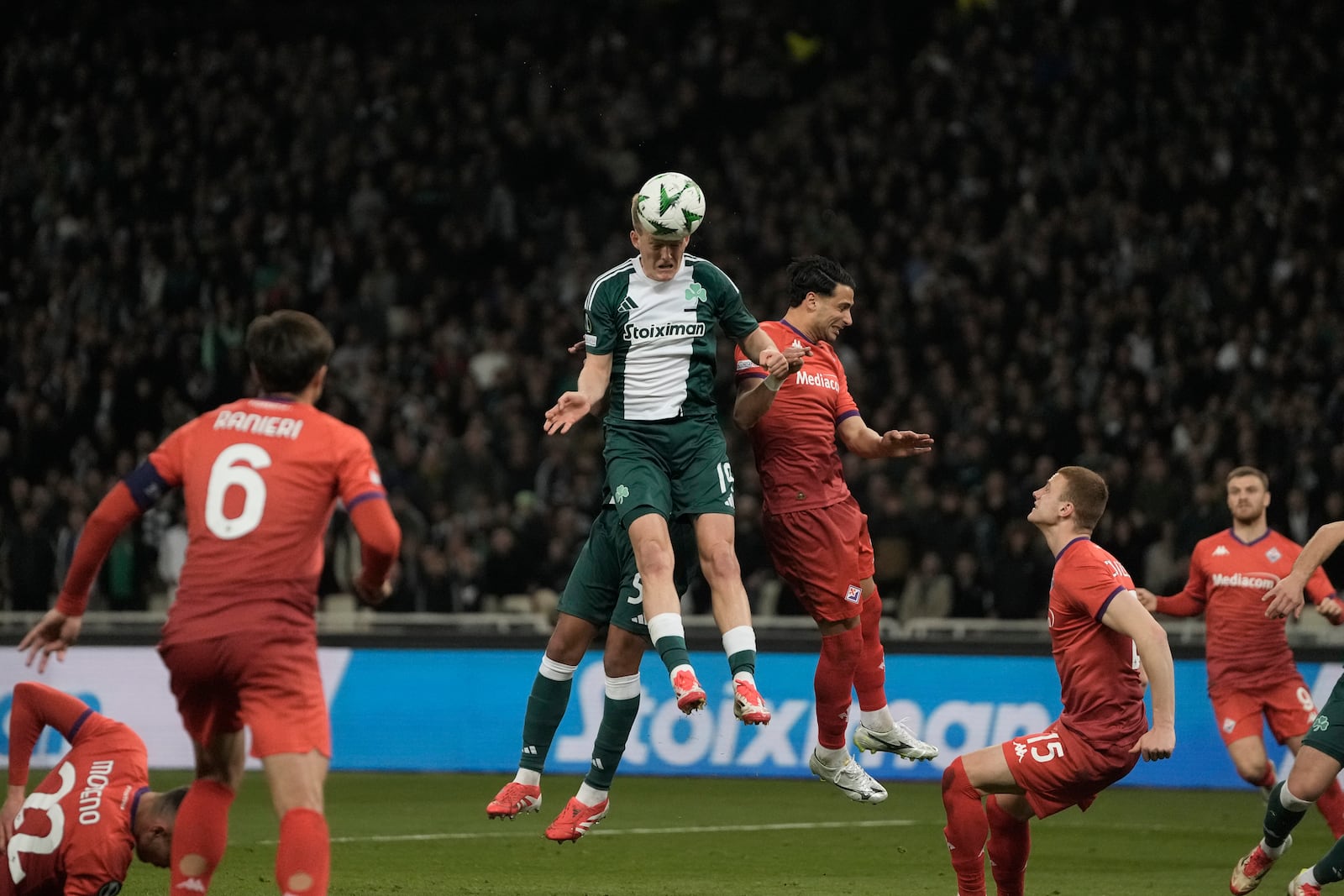 Panathinaikos' Karol Swiderski heads the ball nest to Fiorentina's Rolando Mandragora, right, during the Europa Conference League round of 16 first leg soccer match between Panathinaikos and Fiorentina at the Olympic stadium in Athens, Greece, Thursday, March 6, 2025. (AP Photo/Thanassis Stavrakis)