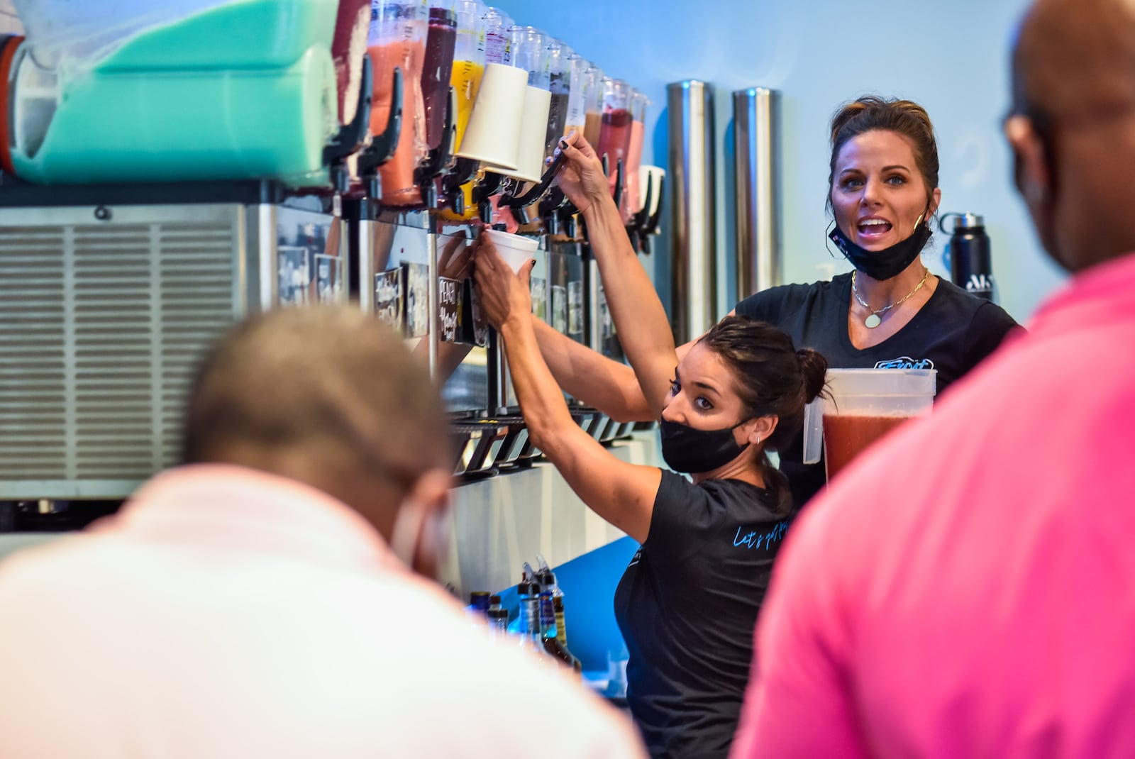 Employee Madeline Garda, left, and co-owner Jamie Gregory talk to customers at The Frost Factory Friday, July 24, 2020 at Liberty Center in Liberty Township. The Frost Factory is now open at Liberty Center in Liberty Township offering boozy and non-alcoholic slushy options in a variety of sizes. Most flavors are made from scratch with fresh fruit and can be customized with alcohol of choice. NICK GRAHAM / STAFF