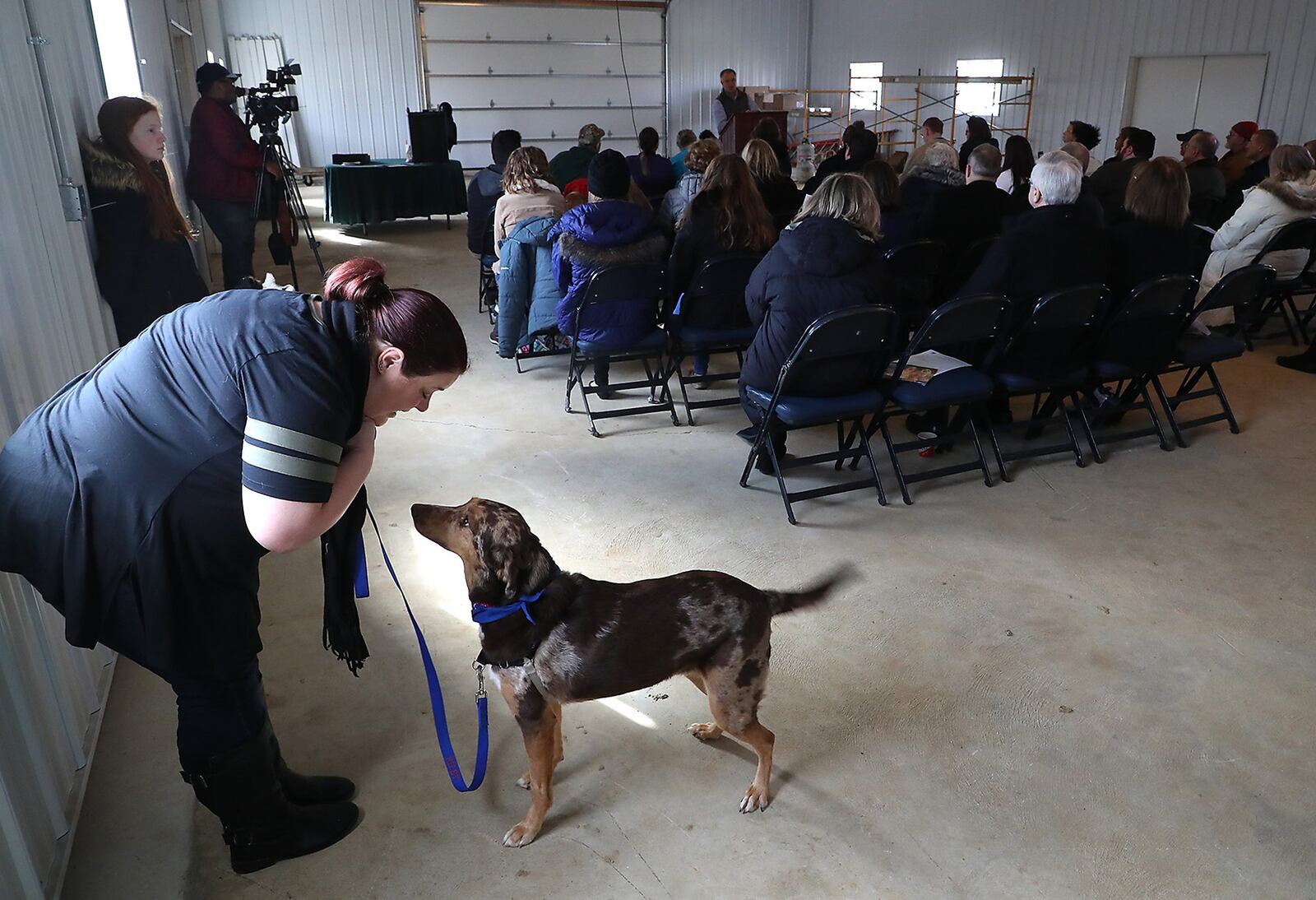 Linda Wierzba keeps her dog, Riley, occupied as the speakers talk during grand opening ceremony of the Caldwell Banker Heritage Dog Barn at the Clark County Fairgrounds Friday. The new barn was built by students at the Clark County Springfield CTC and replaced the old barn that was built in the 1950’s. BILL LACKEY/STAFF