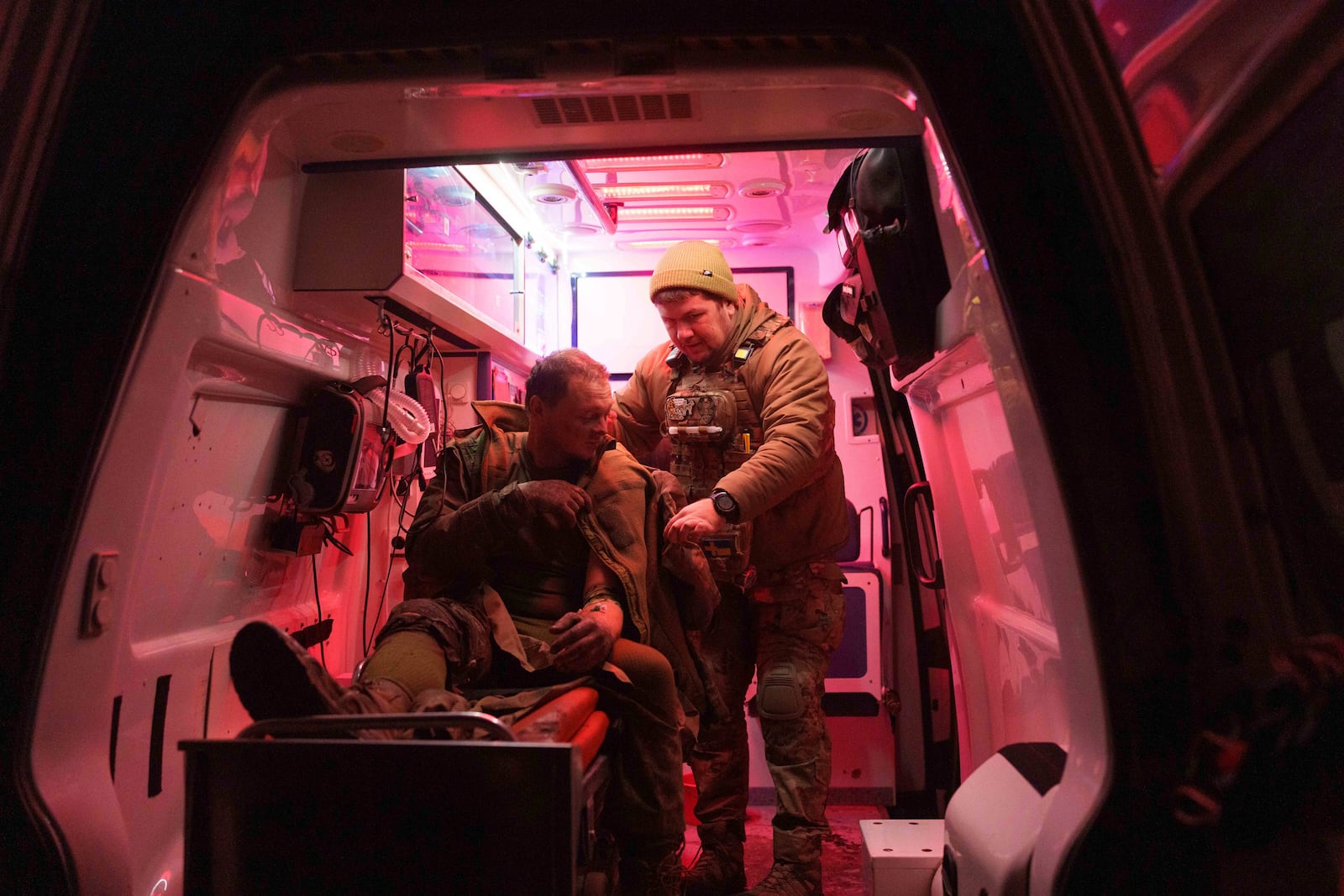 A medic helps an injured Ukrainian serviceman walk out of an ambulance at Medical Service "Ulf" of the 108th Separate Battalion "Da Vinci Wolves" on Pokrovsk direction, Ukraine, Tuesday, Dec. 24, 2024. (AP Photo/Evgeniy Maloletka)