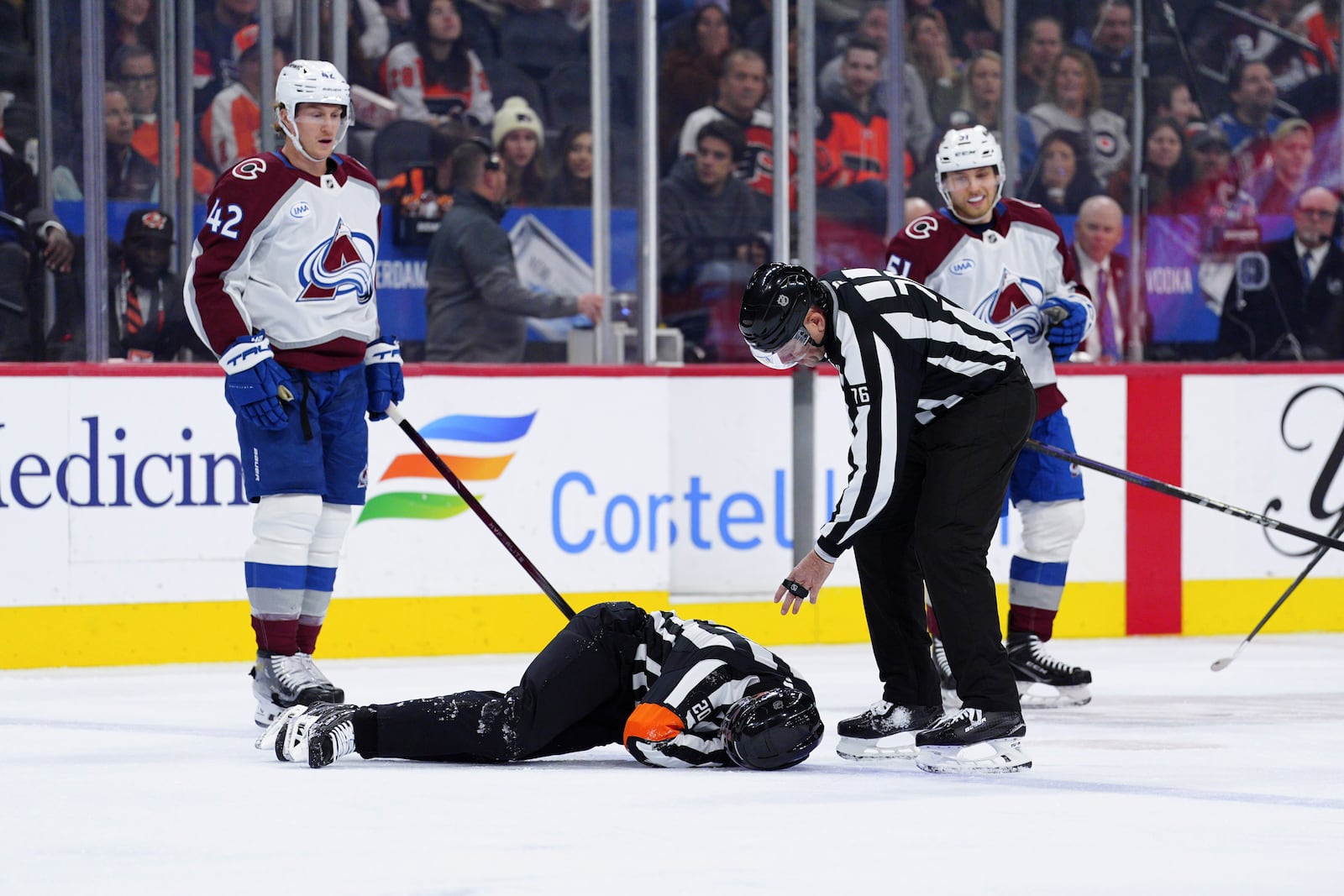 Referee Mitch Dunning, bottom, lies on the ice after an injury during the first period of an NHL hockey game between the Philadelphia Flyers and the Colorado Avalanche, Monday, Nov. 18, 2024, in Philadelphia. (AP Photo/Derik Hamilton)