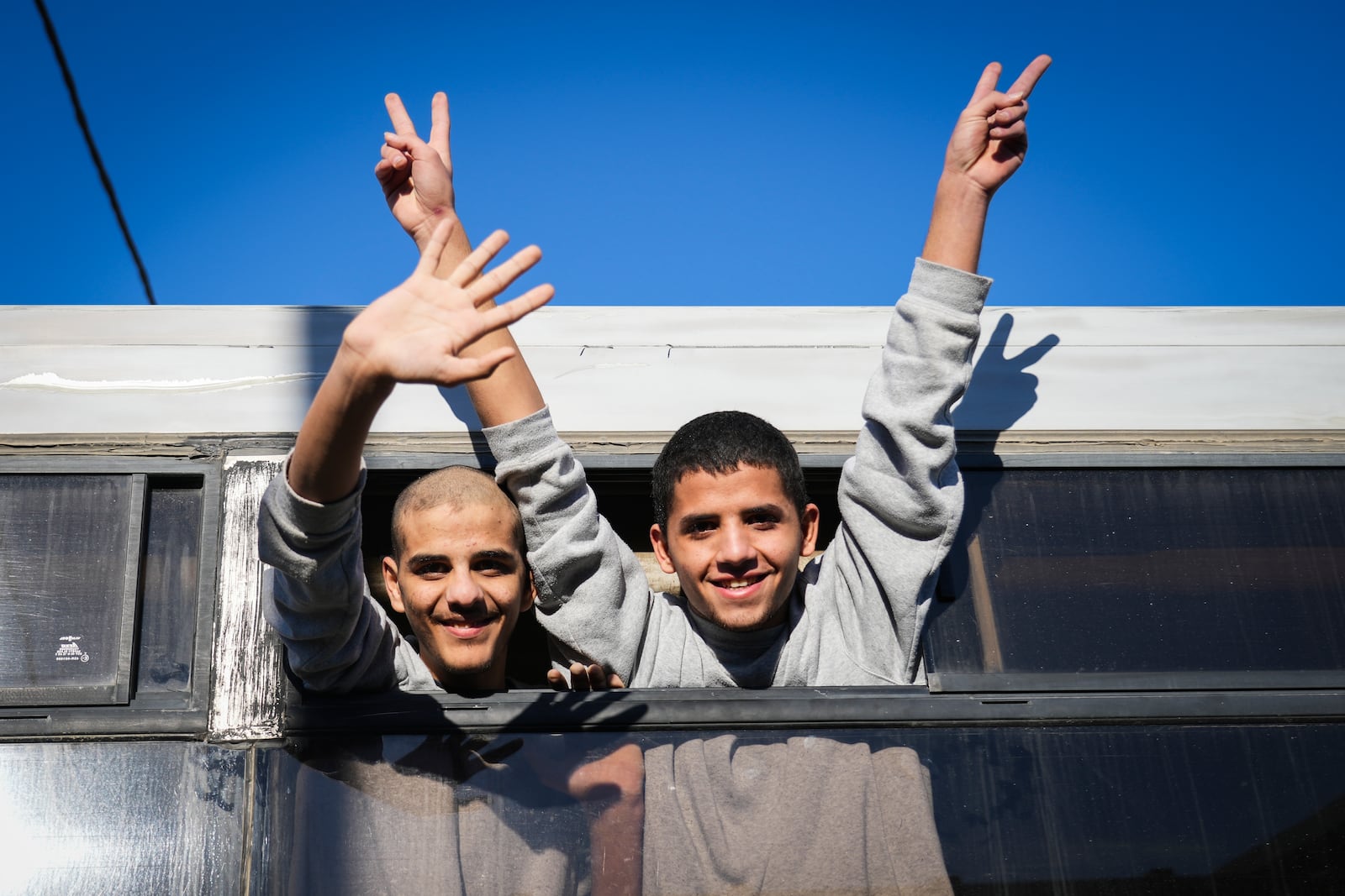 Freed Palestinian teenagers wave as they are greeted upon their arrival after being released from detention in an Israeli prison in Khan Younis, Gaza Strip, Thursday, Feb. 27, 2025. (AP Photo/Abdel Kareem Hana)