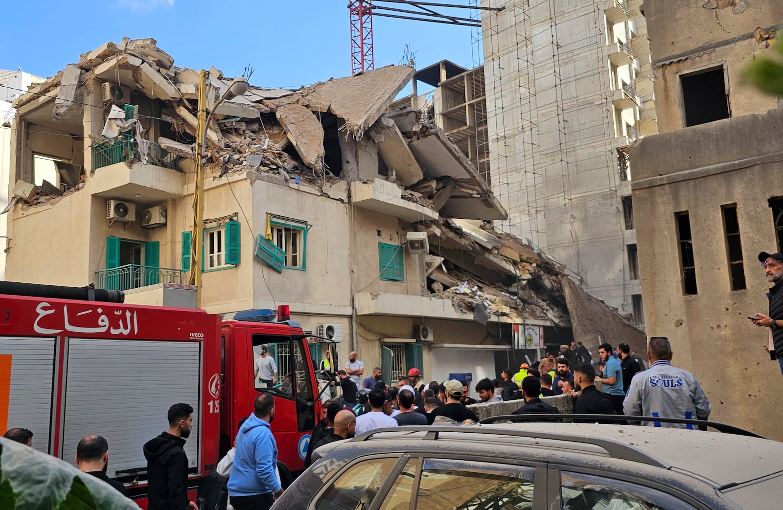 Residents and rescuers gather at the site of an Israeli airstrike that hit a building in central Beirut's Ras el-Nabaa neighborhood, Lebanon, Sunday, Nov. 17, 2024. (AP Photo/Hassan Ammar)