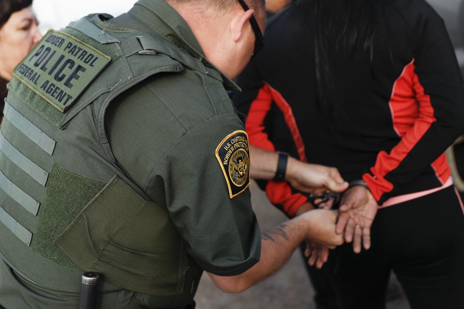 A government agent takes a suspect into custody during an immigration sting at Corso’s Flower and Garden Center, Tuesday, June 5, 2018, in Castalia, Ohio. The operation is one of the largest against employers in recent years on allegations of violating immigration laws. (AP Photo/John Minchillo)