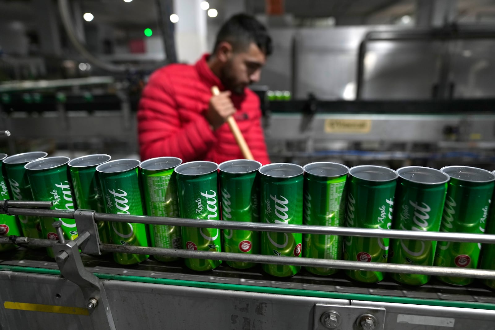 Cans of Chat Cola Company brand Chat Apple soft drink move along a production line in the Palestinian company's bottling plant, in the West Bank city of Salfit, Feb. 13, 2025. (AP Photo/Nasser Nasser)