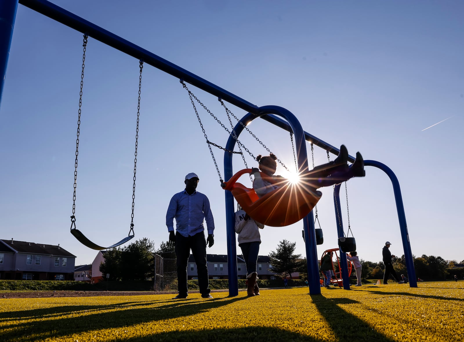 Bernard Awuah-Peasah pushes his daughter, Nhyira, 6, on the swings at the new playground at Liberty Park Thursday, Oct. 17, 2024 on Yankee Road in Liberty Township. NICK GRAHAM/STAFF